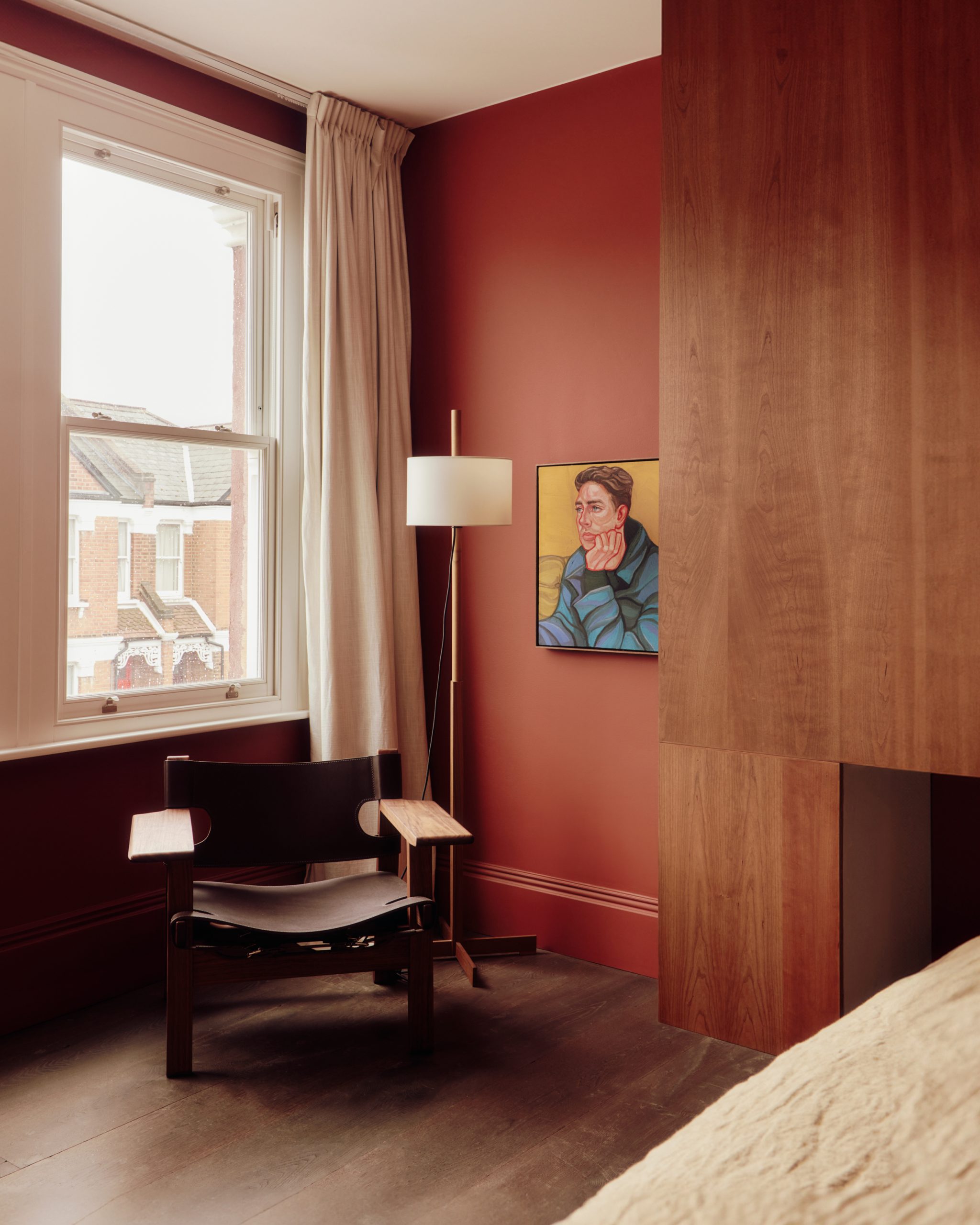 Deep-red walls and cherry joinery define the main bedroom.