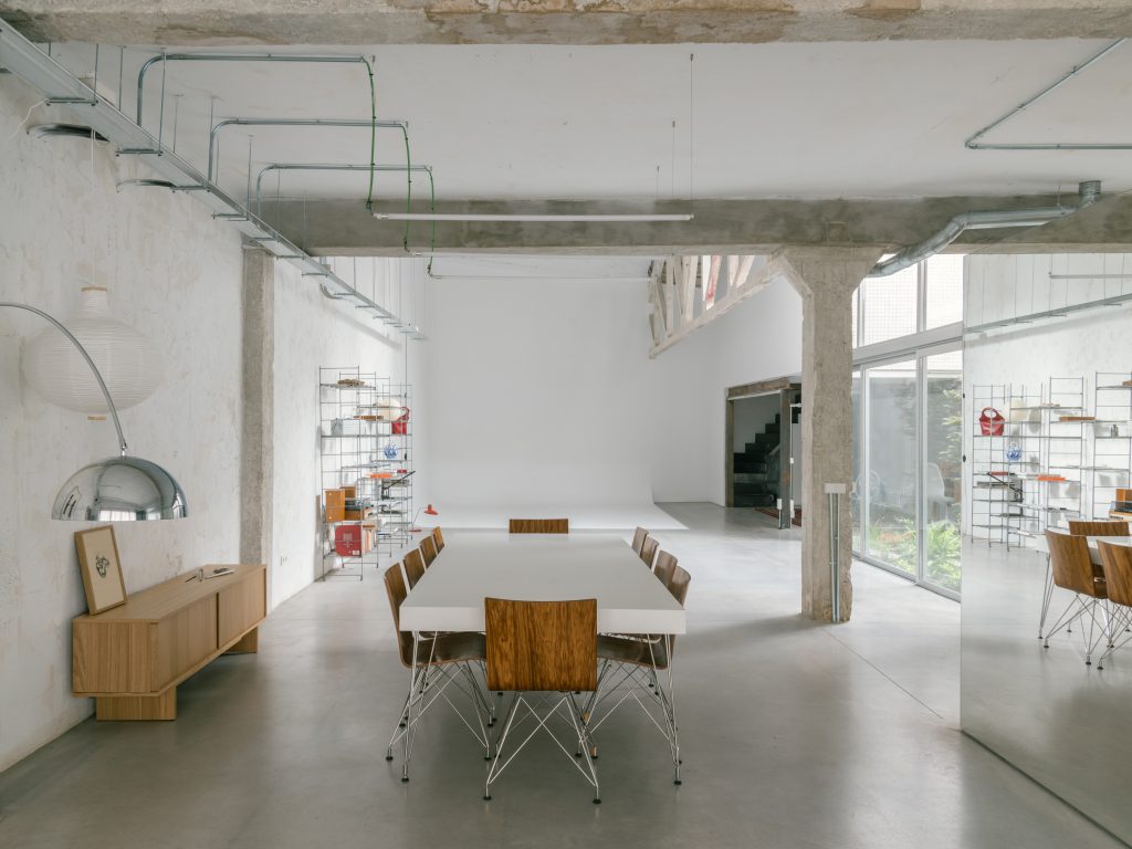 The open industrial hall is organised around a mirrored volume and courtyard.