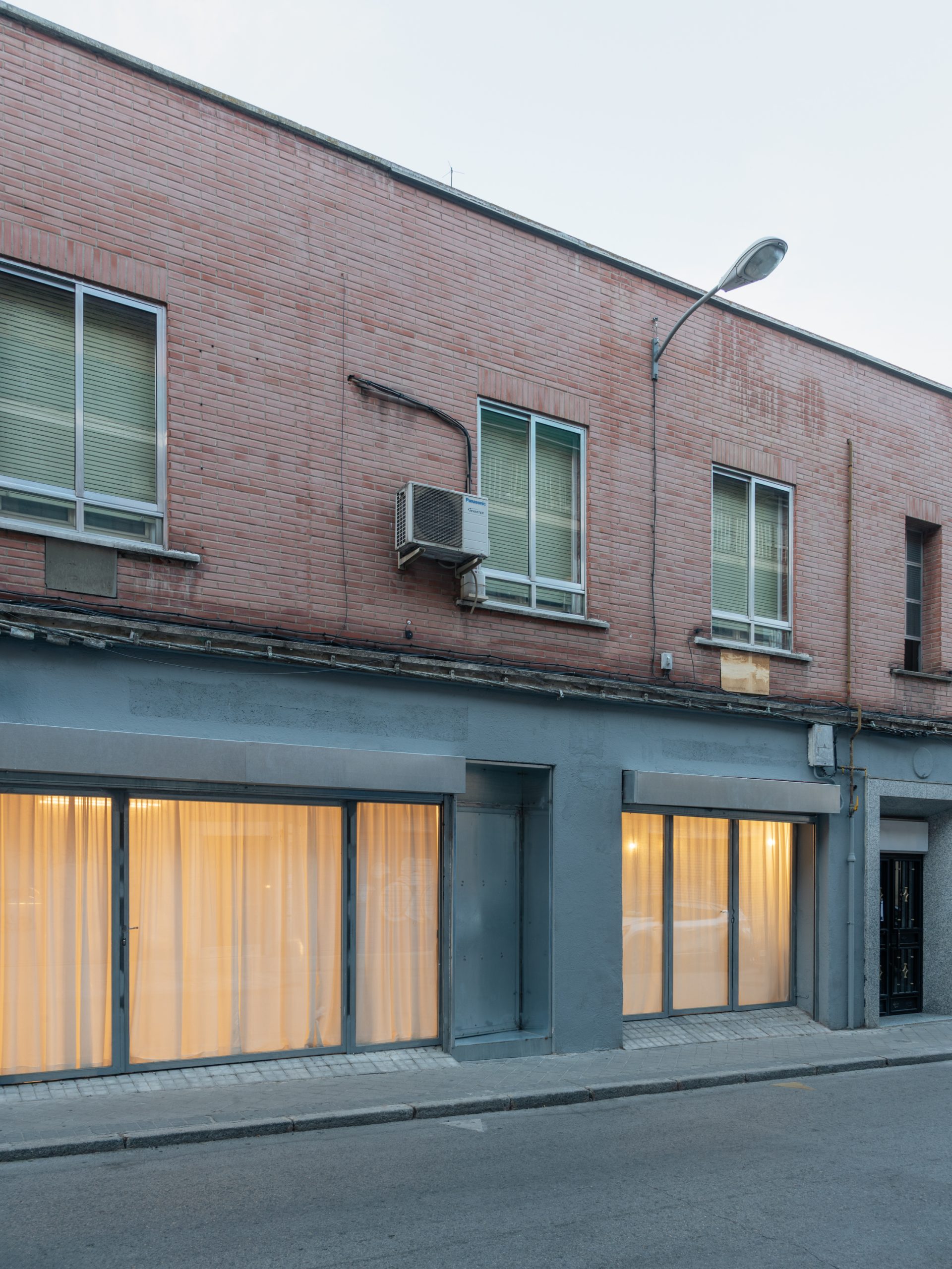 ABG occupies an industrial space behind a brick street facade in Madrid.