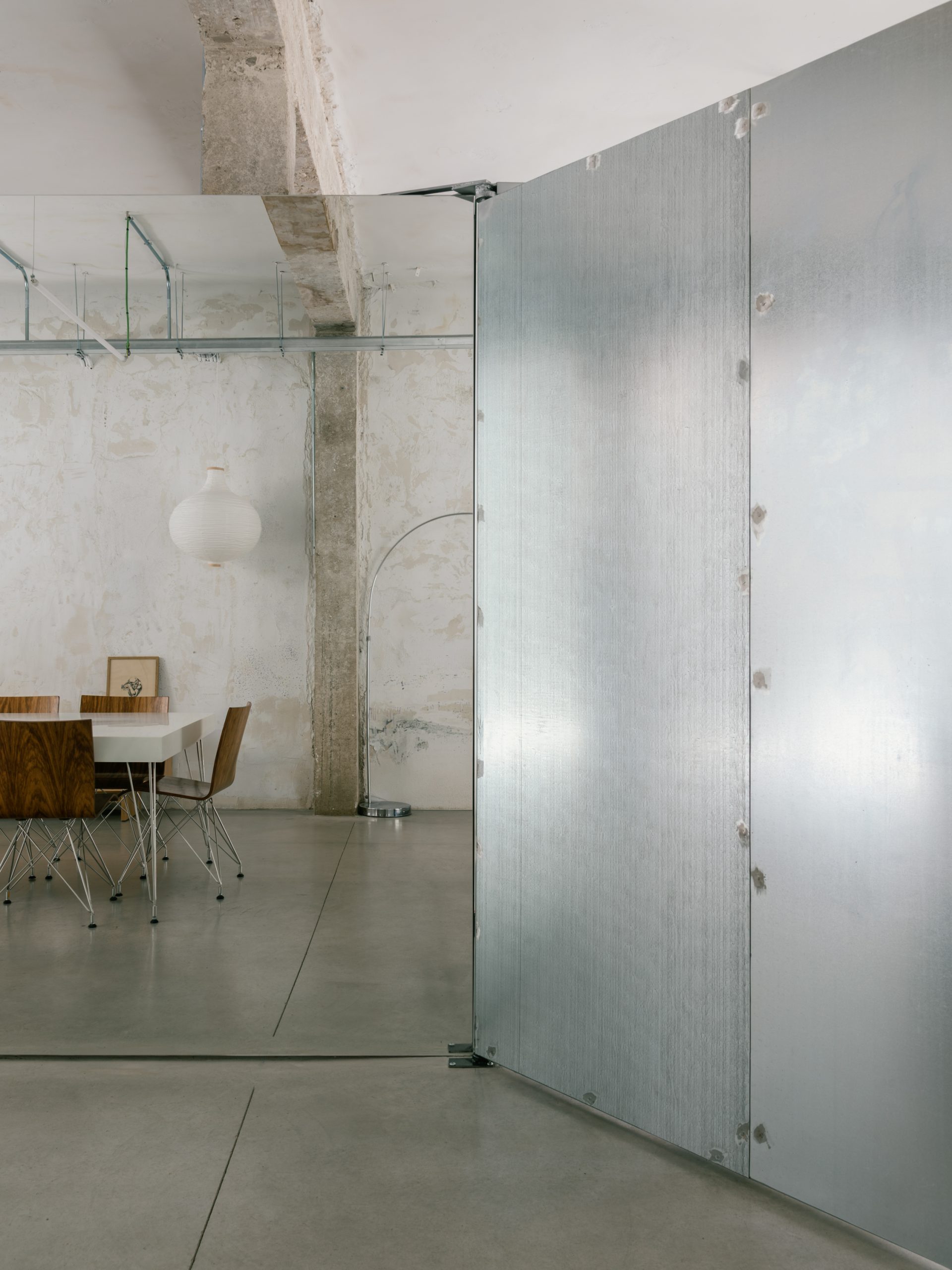 A pivoting metal wall changes circulation through the open interior.
