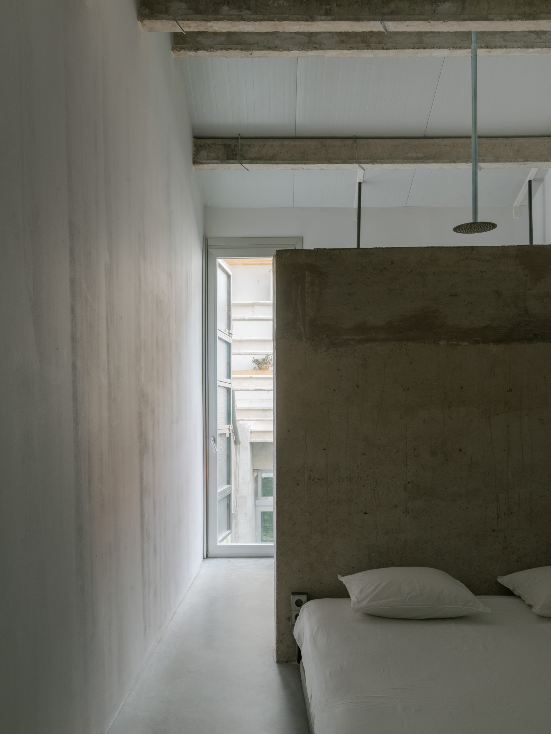 A cast-in-situ concrete wall defines the sleeping area.