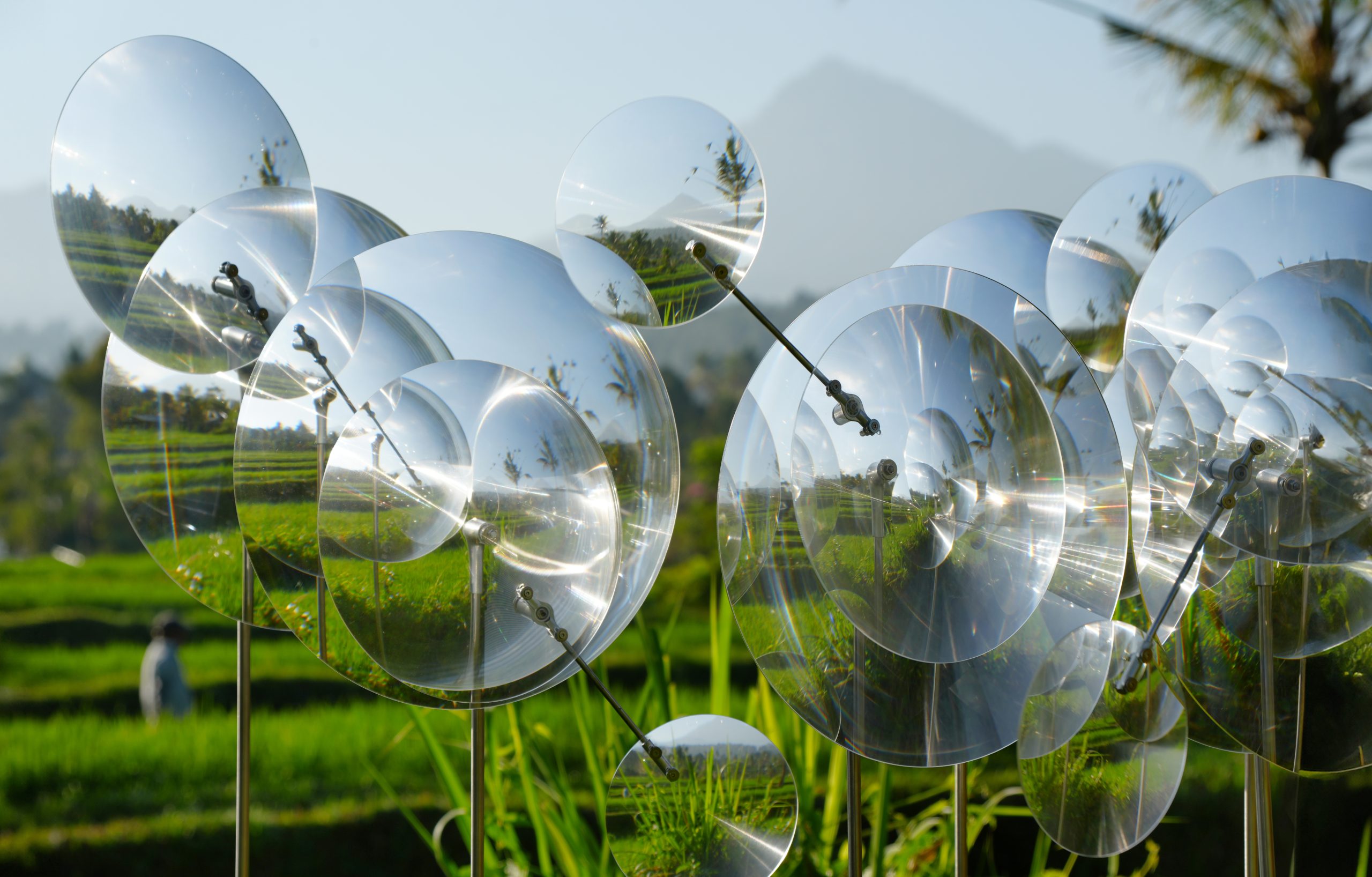 Overlapping Fresnel lenses fragment views of the rice fields and distant landscape.