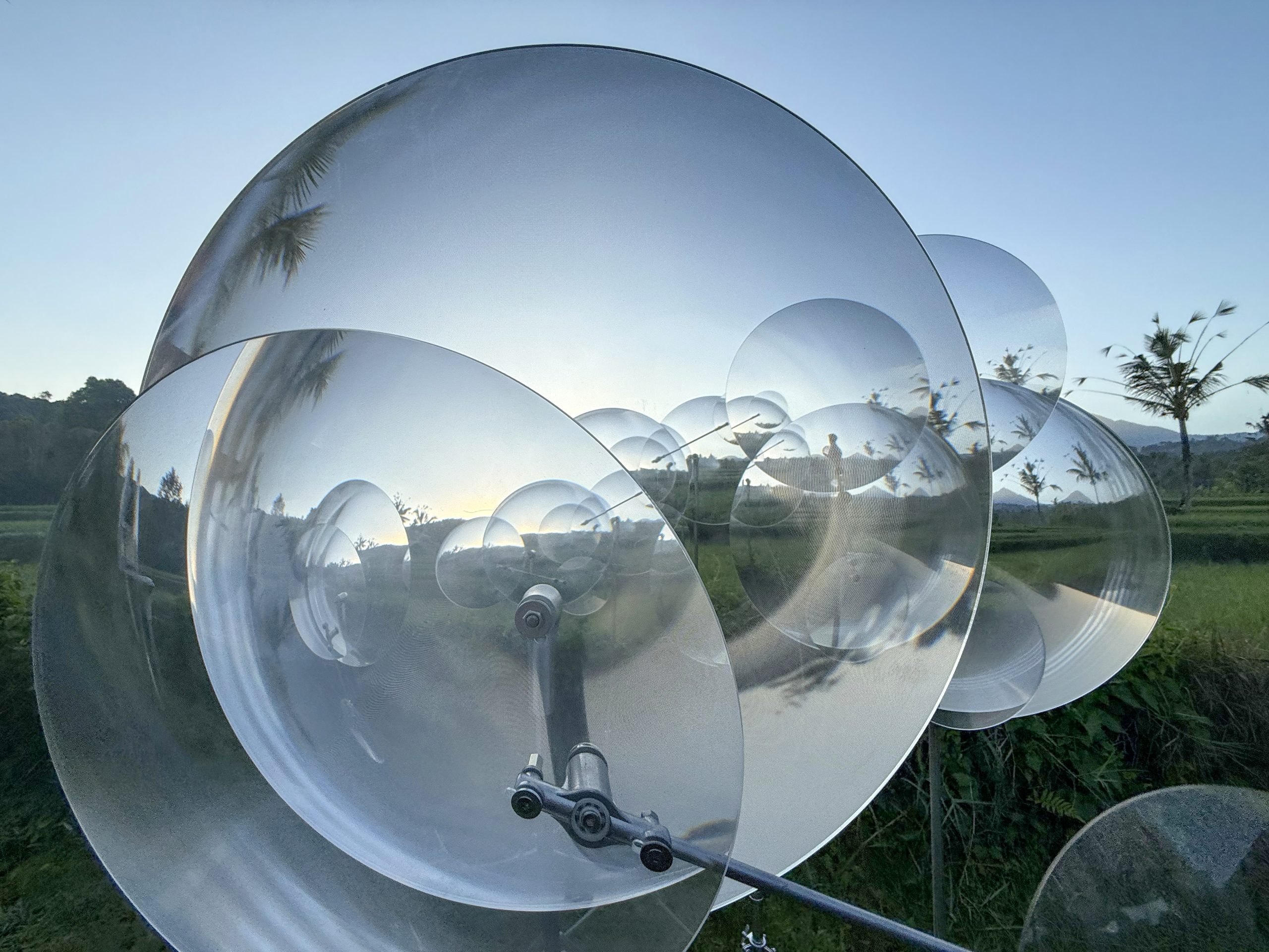 A detail of the lens assembly shows its off-centre attachment and slender supports.