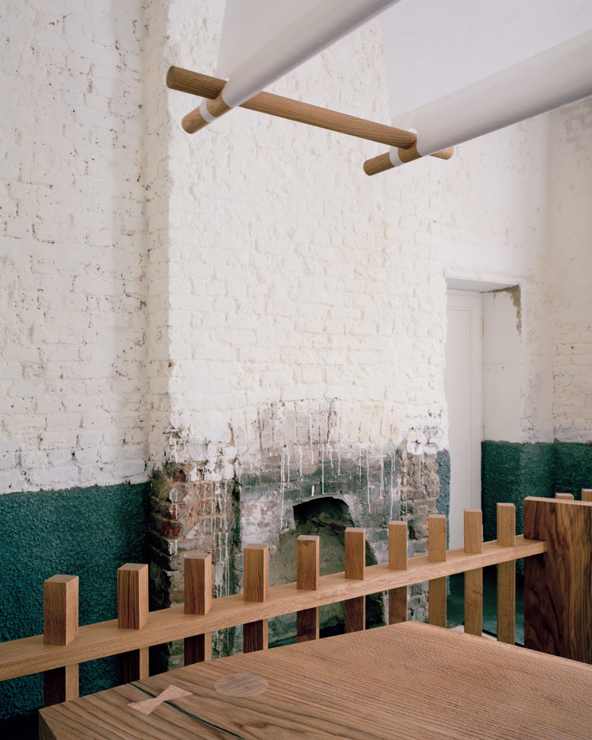 Oak stools and lighting against limewashed brick walls