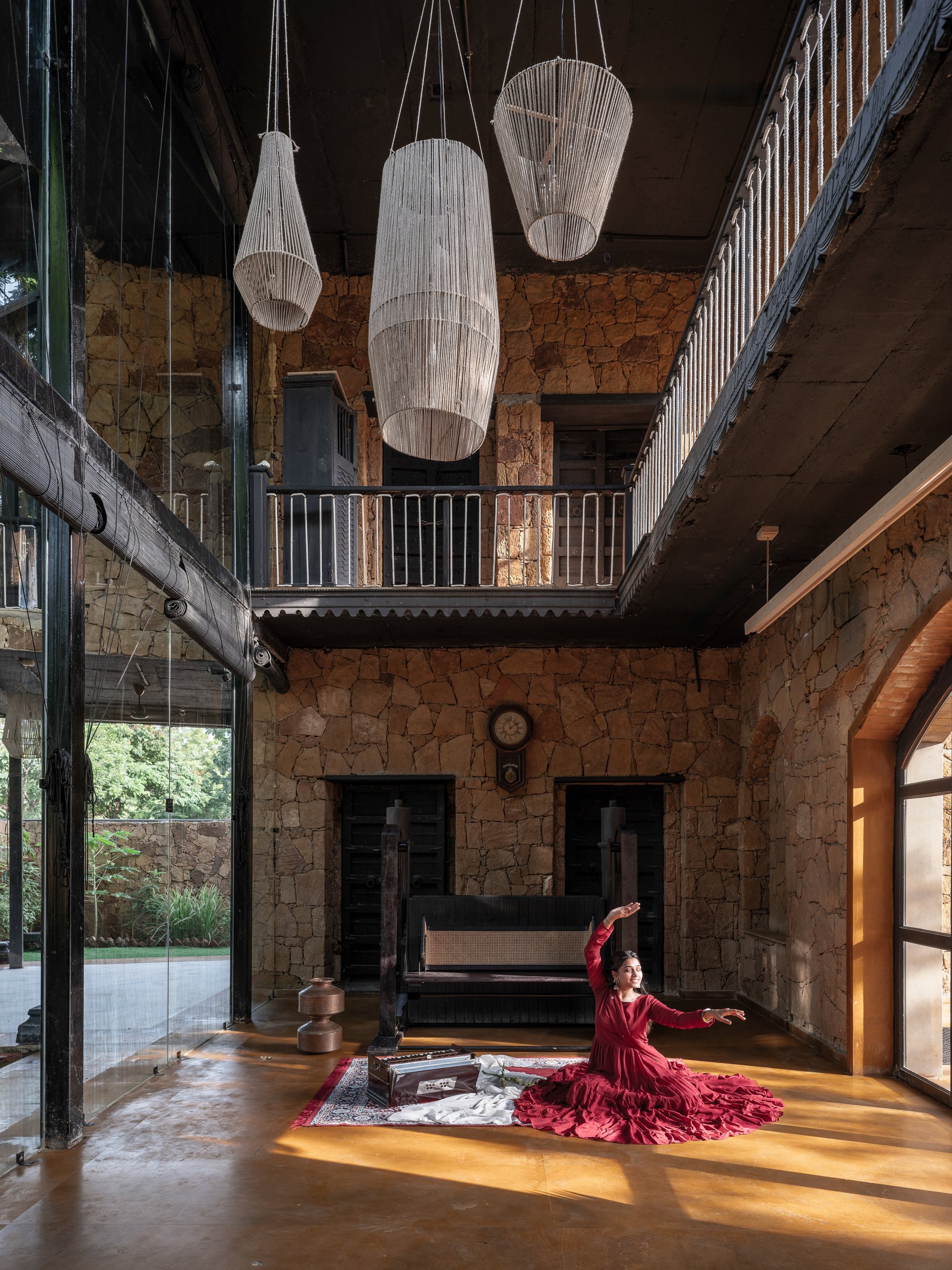Double height living room with suspended lights and a circular skylight