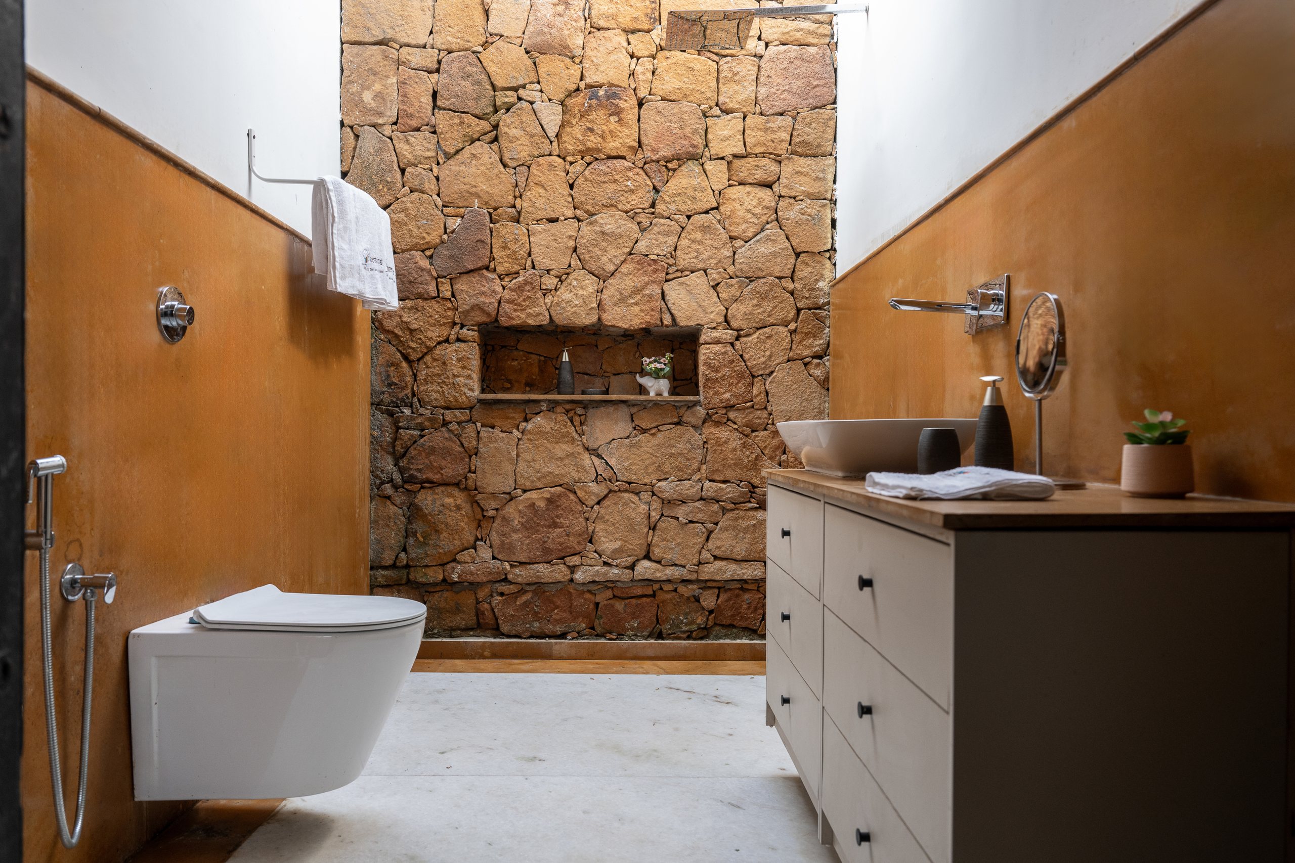 Bathroom with sandstone wall and daylight from above