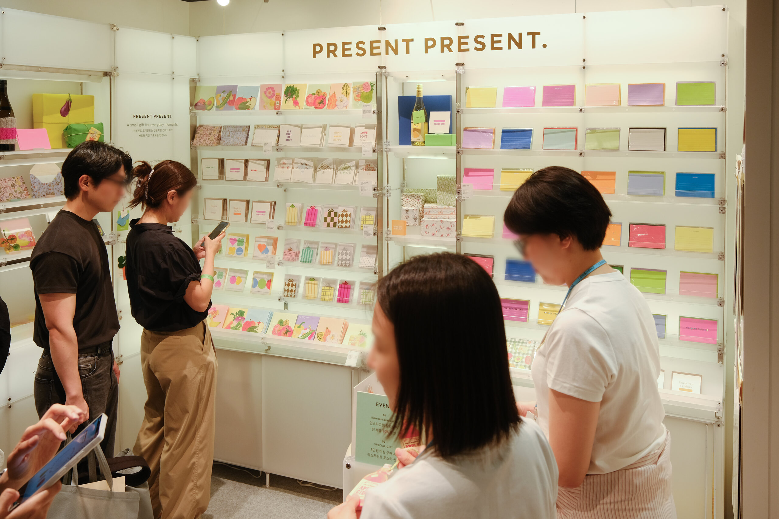 Visitors browsing the PRESENT PRESENT display at COEX