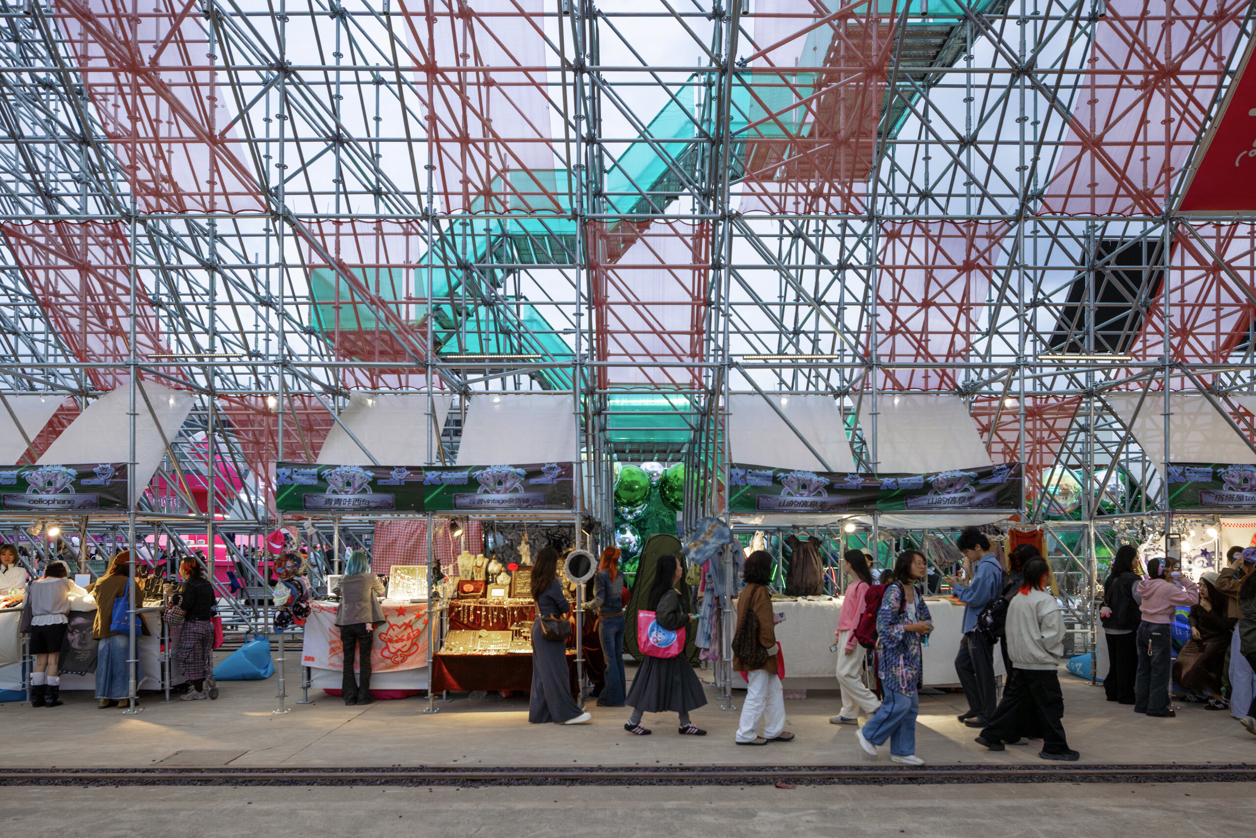 Market stalls arranged beneath the scaffolding structure
