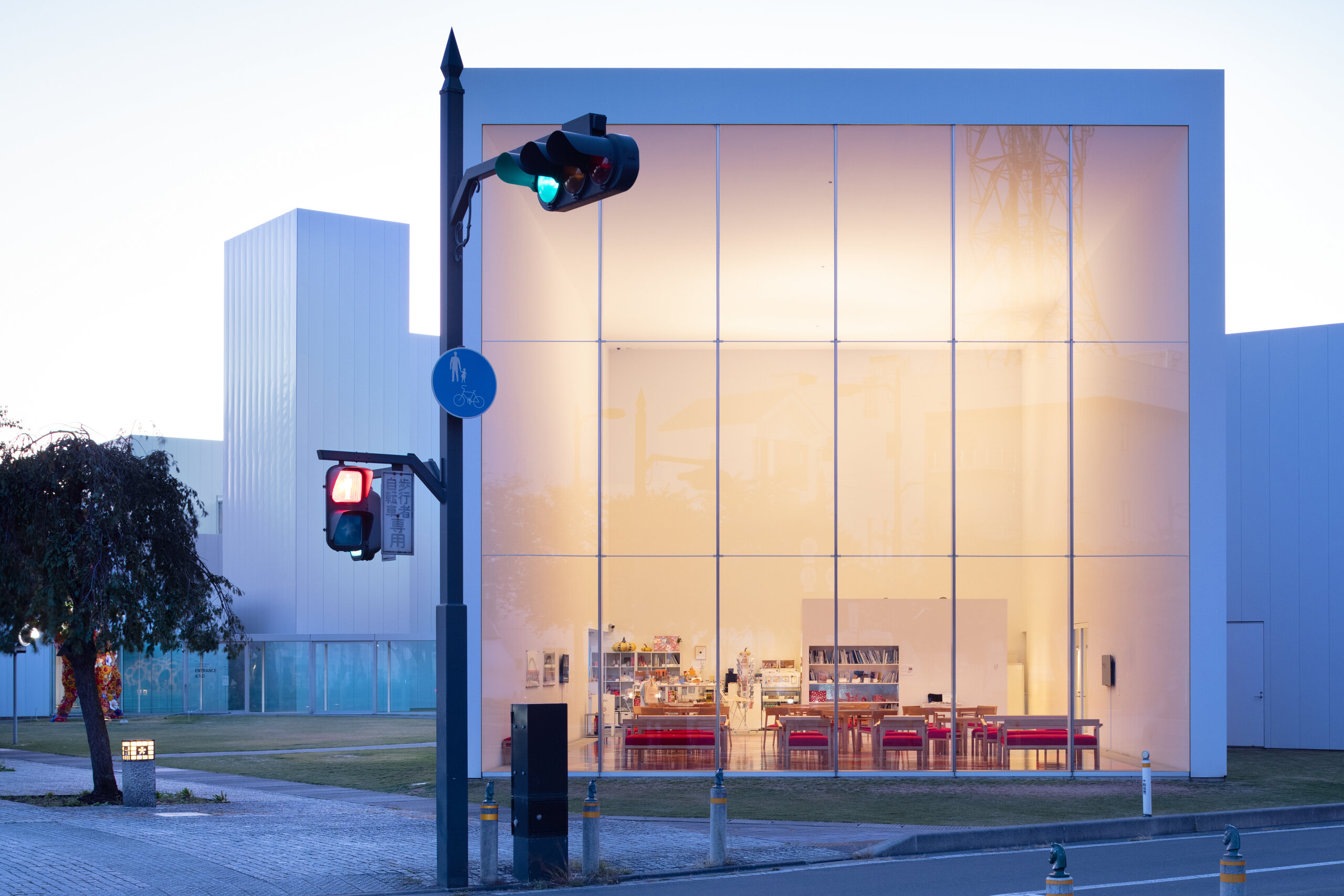 Towada Art Center glowing behind a city street in Aomori