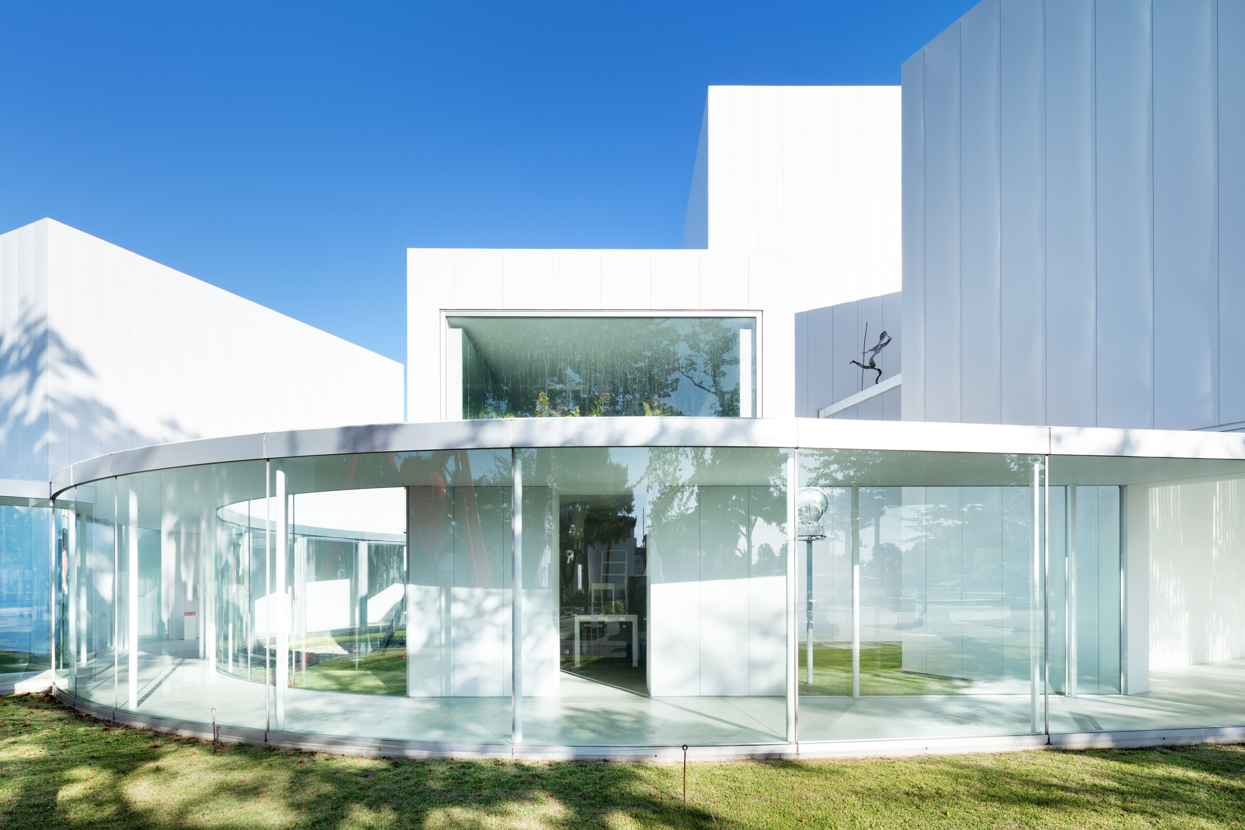 Curved transparent corridor connecting galleries at Towada Art Center