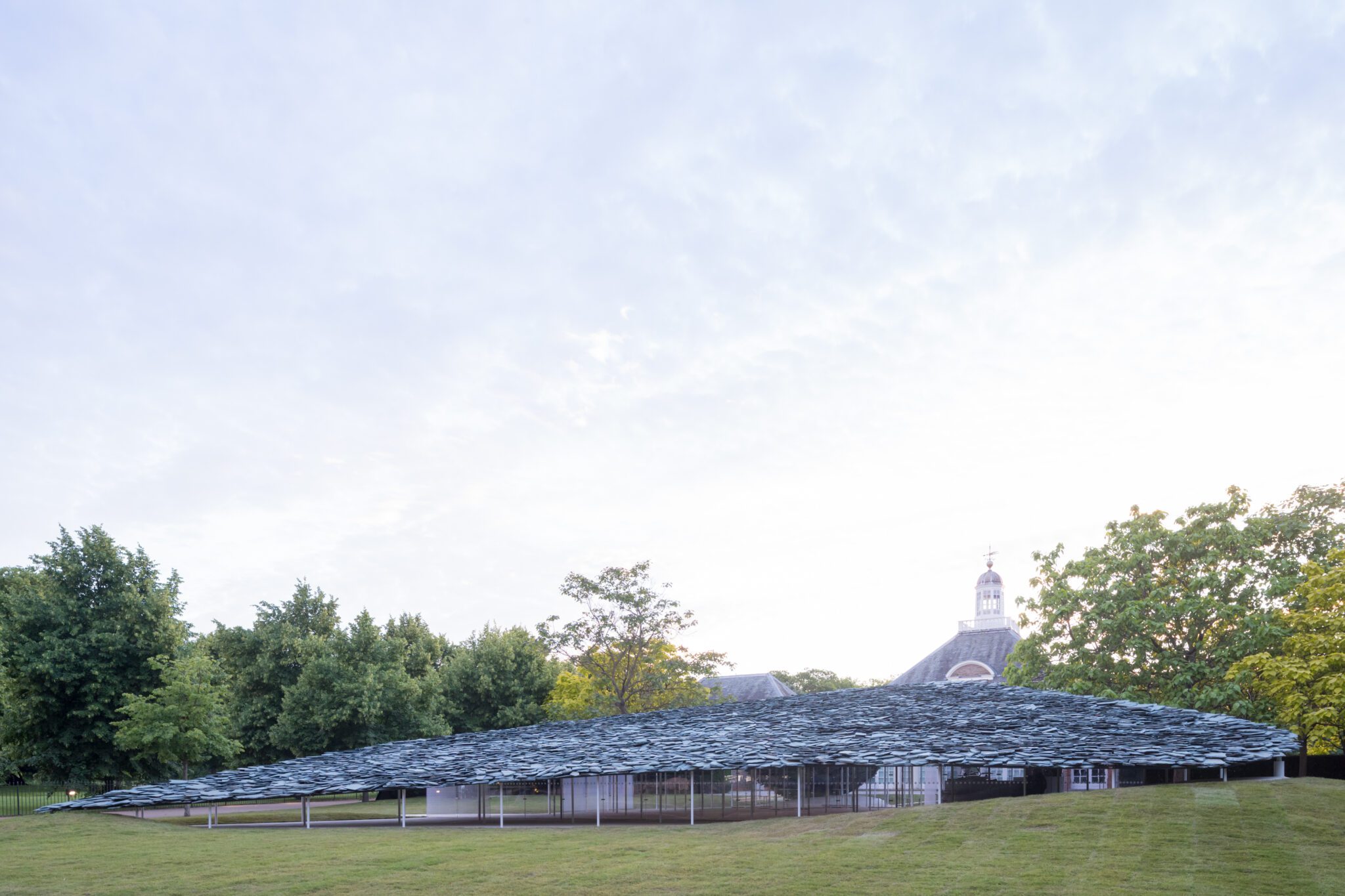 Junya Ishigami’s slate canopy appears to rise from the surrounding park. © Junya Ishigami + Associates; photograph by Norbert Tukaj.