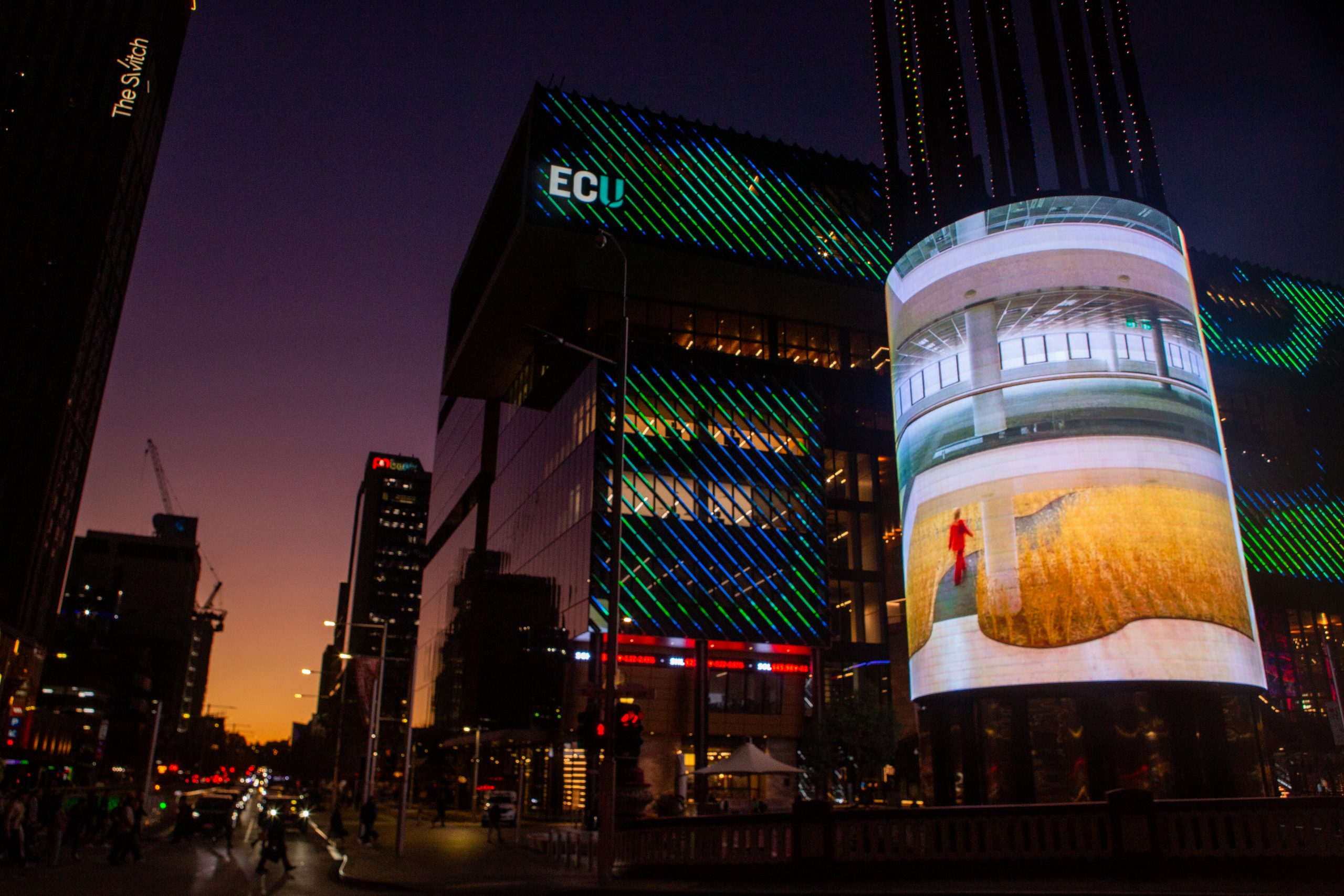 The wheat field artwork illuminates a building at Yagan Square in Perth at night