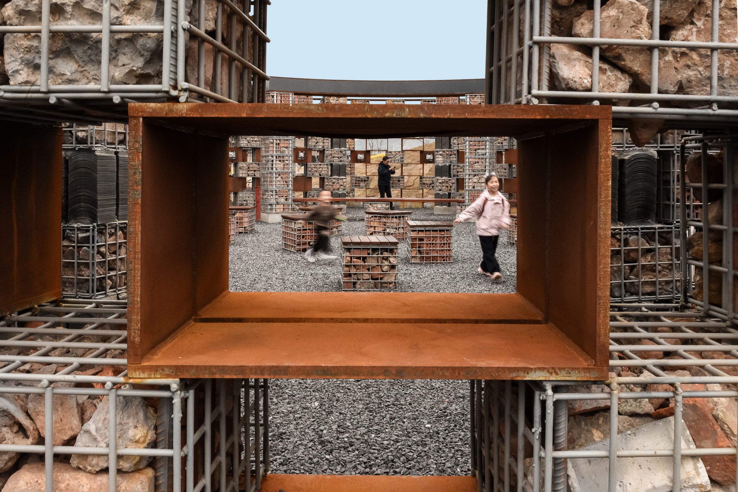 The museum’s circular brick-and-gabion wall seen through a window