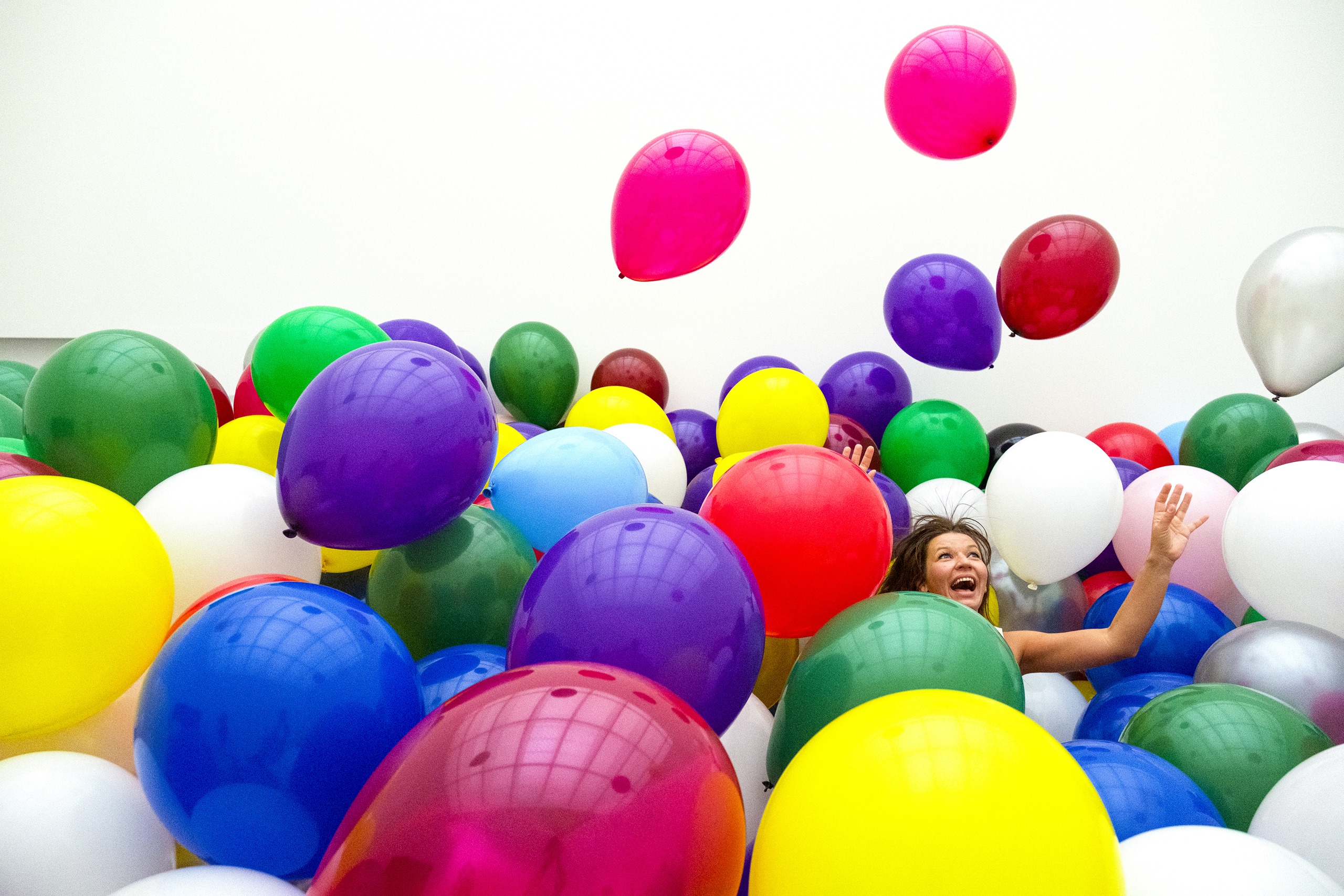 Visitor surrounded by brightly coloured balloons in Martin Creed’s installation.