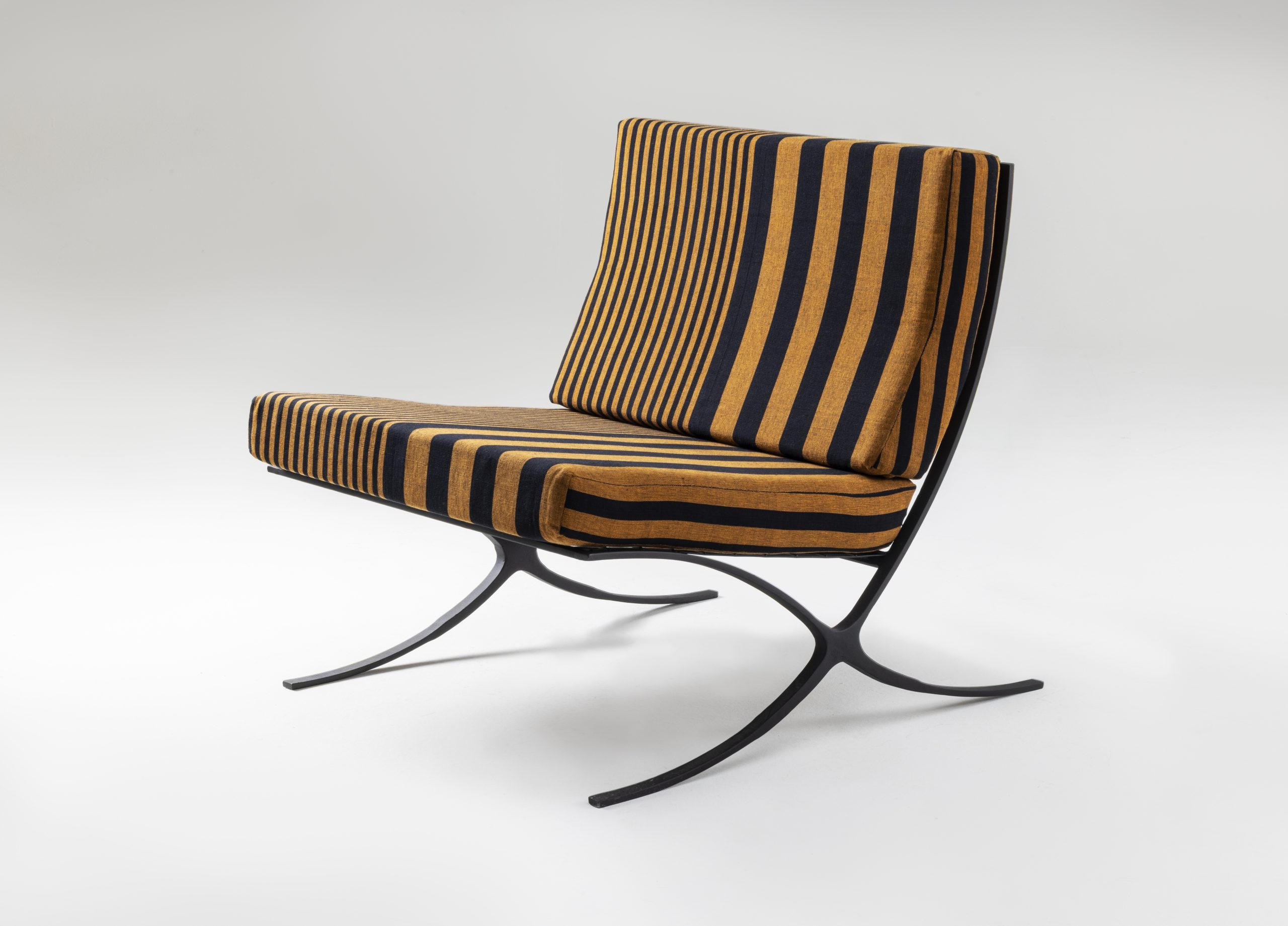 Lounge chair with welded iron rod and mesh frame, upholstered in Barbara Sansoni fabric