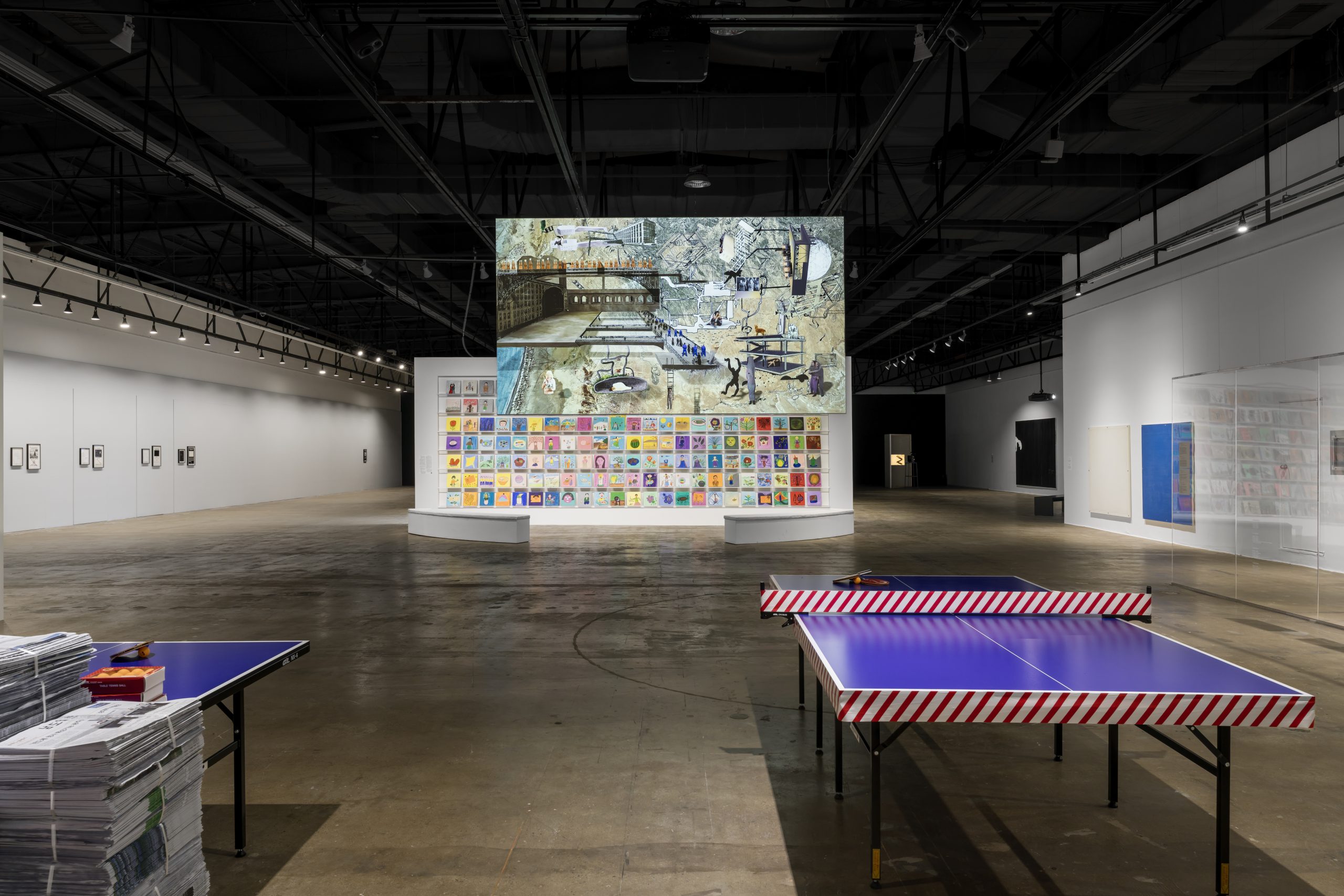 Gallery 2 installation view with striped platforms and a suspended image display