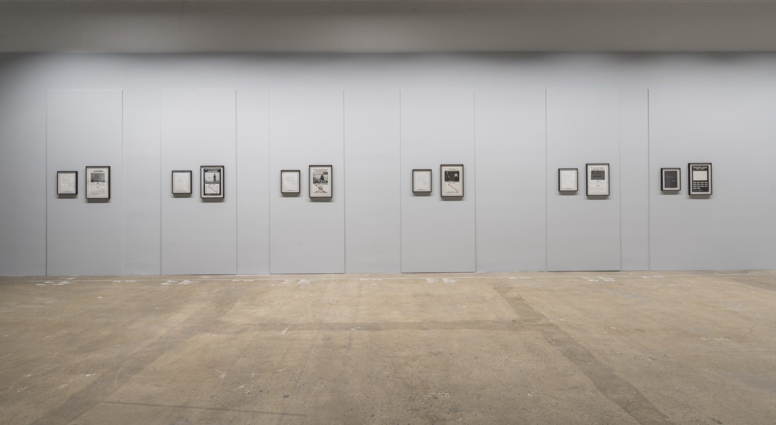 Documentation of Tehching Hsieh's performances arranged along a gallery wall