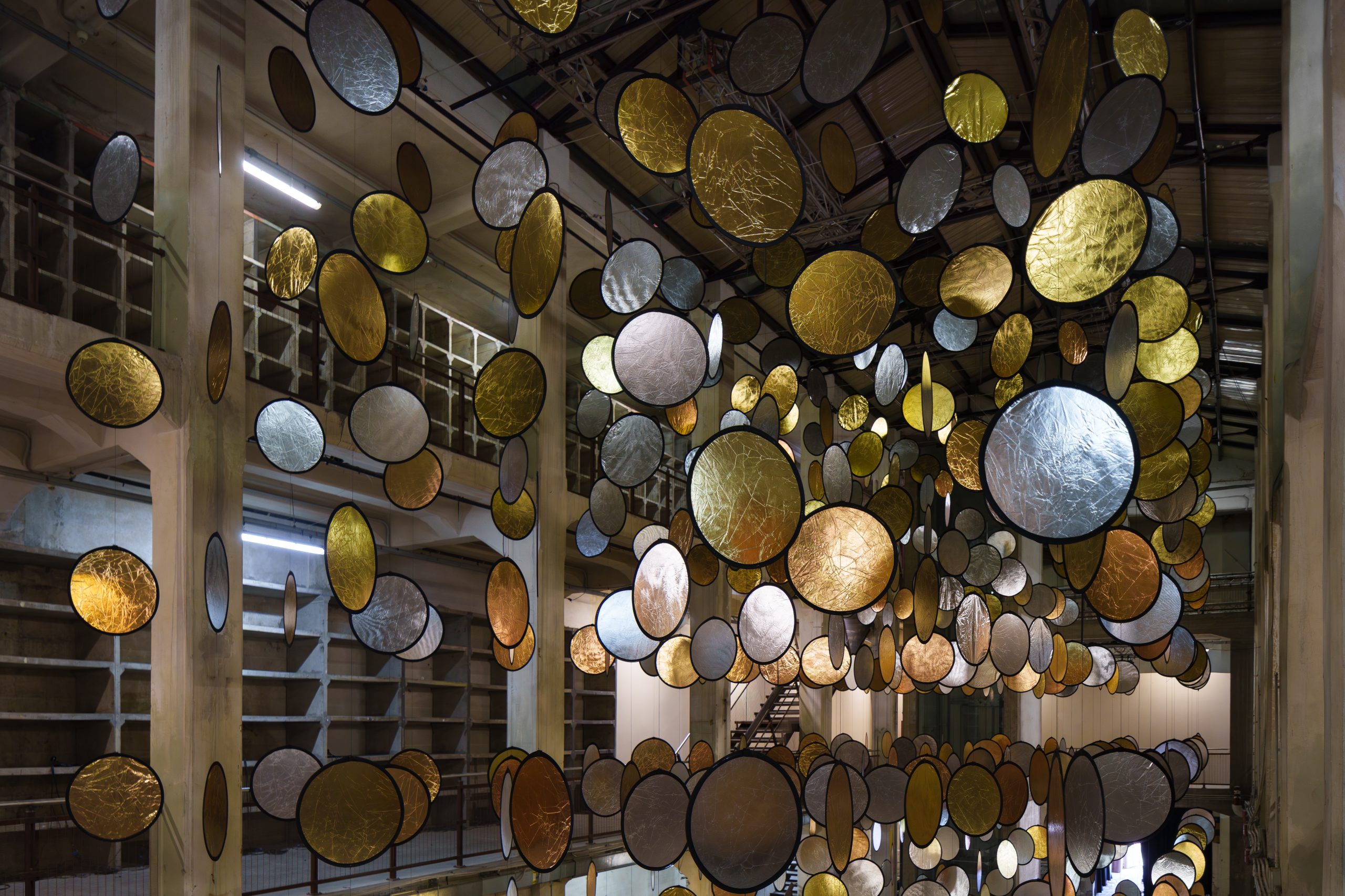 HALOS reflective circles framed by the factory's concrete columns and walkways
