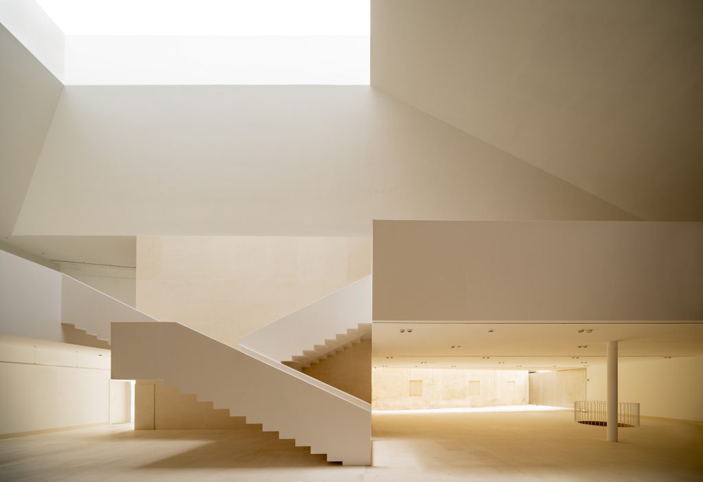 Daylit atrium and sculptural staircase at Marchena Archaeological Museum