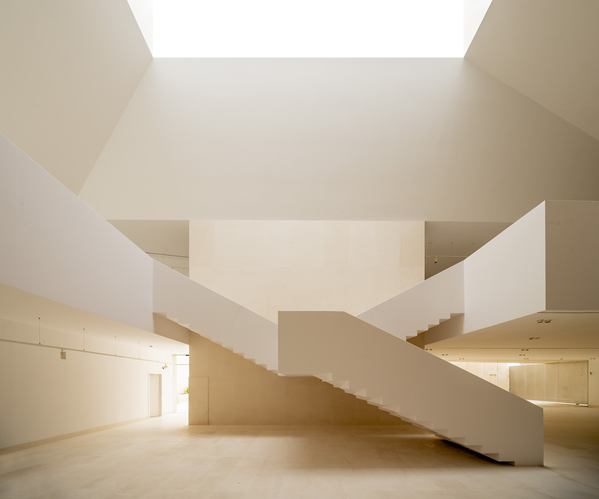 Staircase beneath a large roof opening at Marchena Archaeological Museum