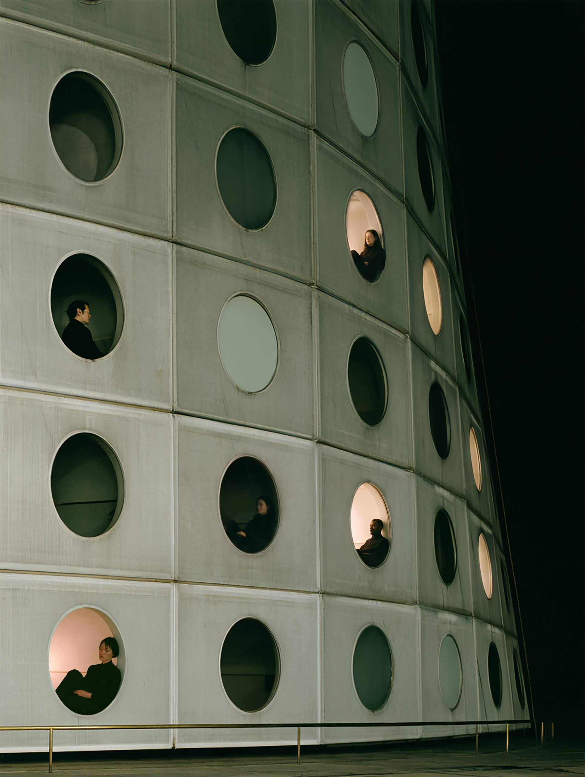 Rows of circular openings reveal individual inhabitants within a modular facade