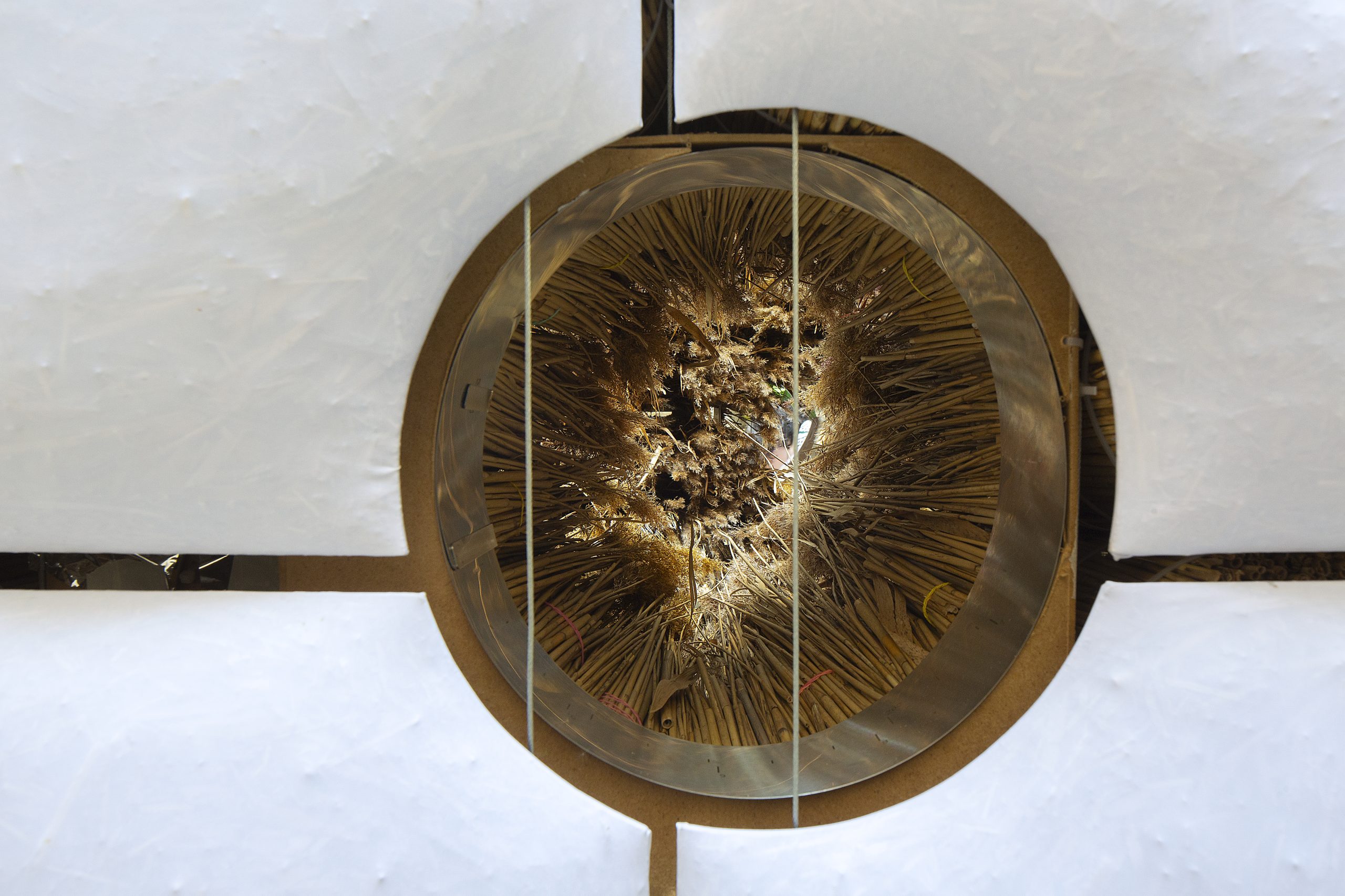 Circular opening revealing bundled reed behind the pillows