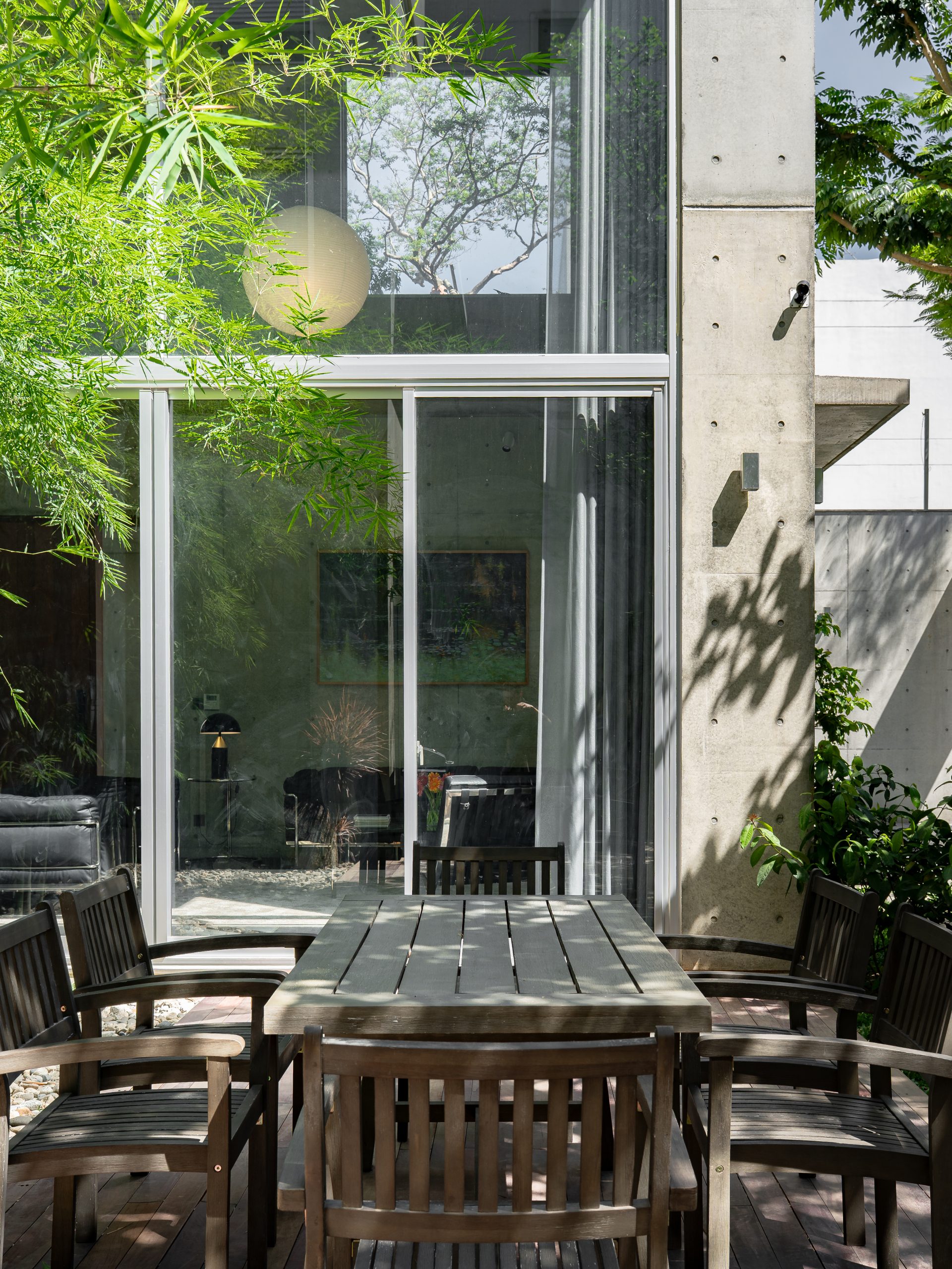 Courtyard table beside glazed living spaces, House K by HGAA