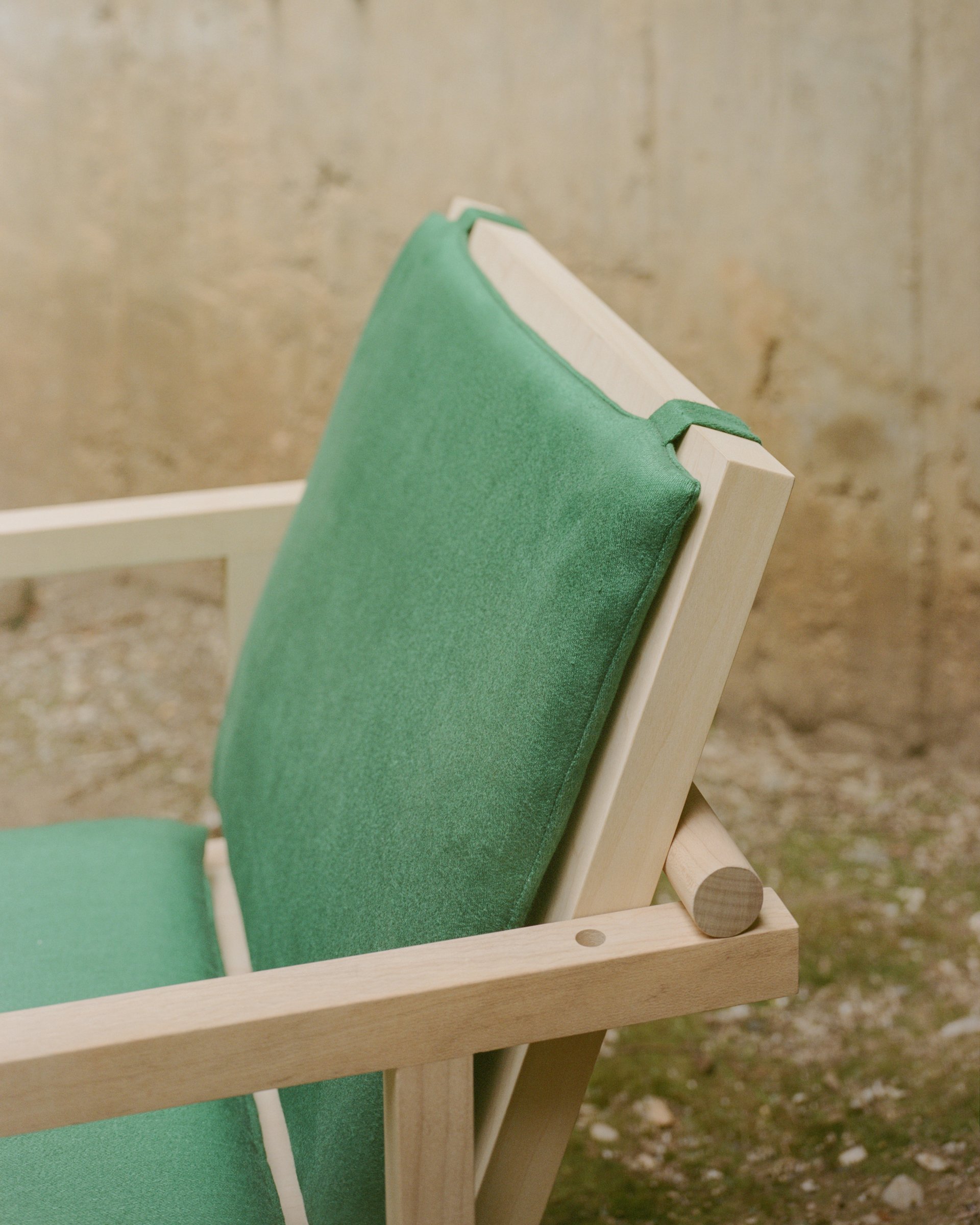 Exposed maple joinery and green back cushion of the Parrot Chair