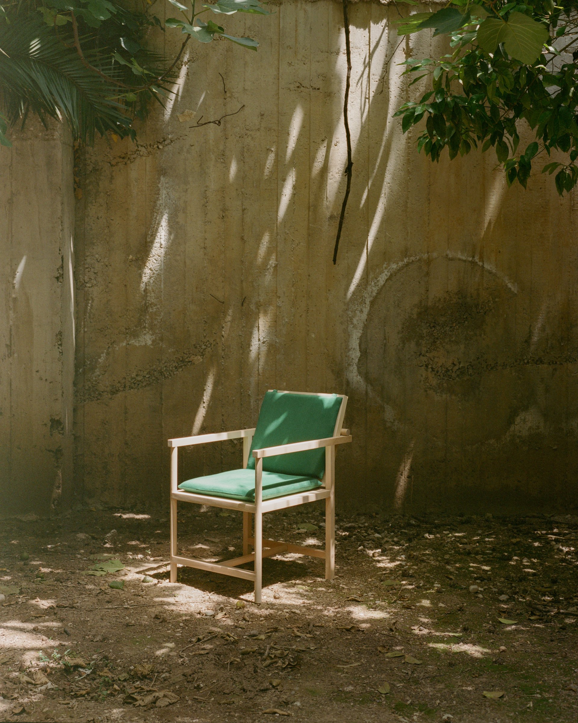 Parrot Chair beneath trees in an Athens courtyard