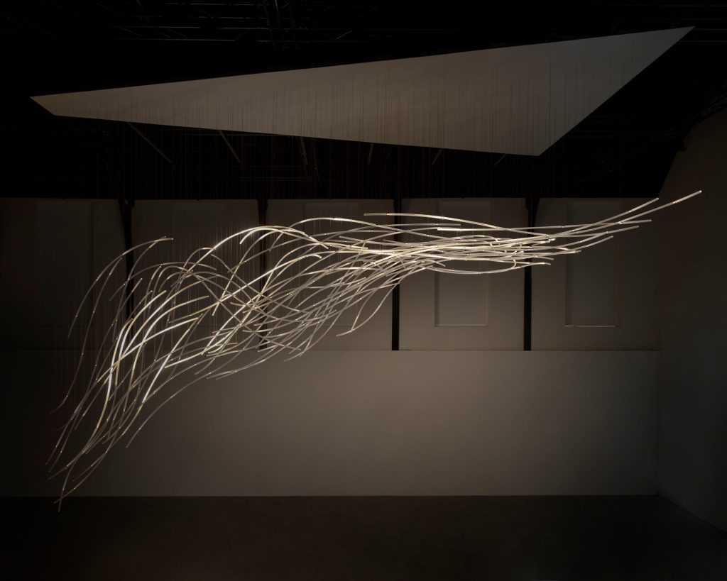 Aeolus glass strands extending across the dark gallery