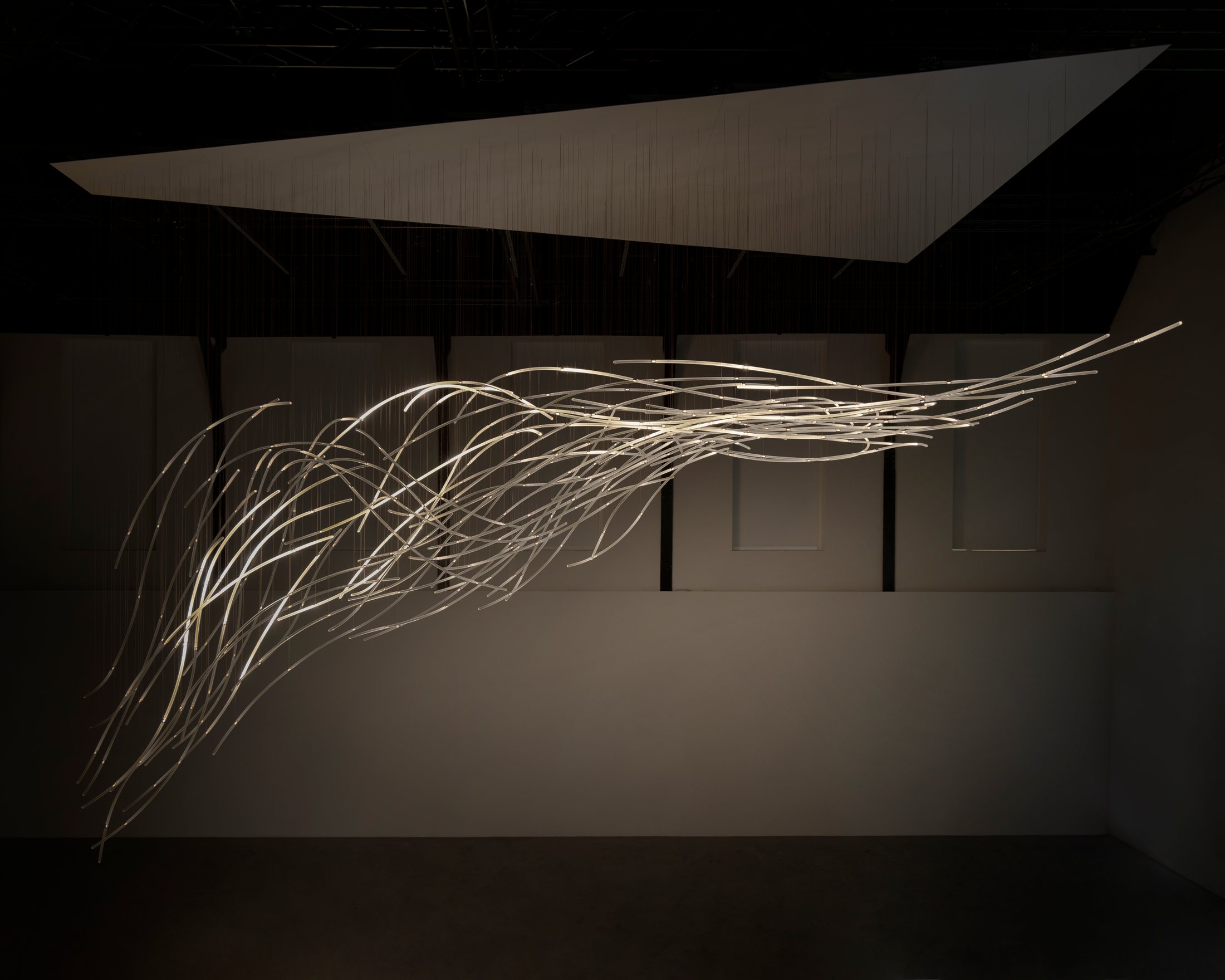Aeolus glass strands extending across the dark gallery