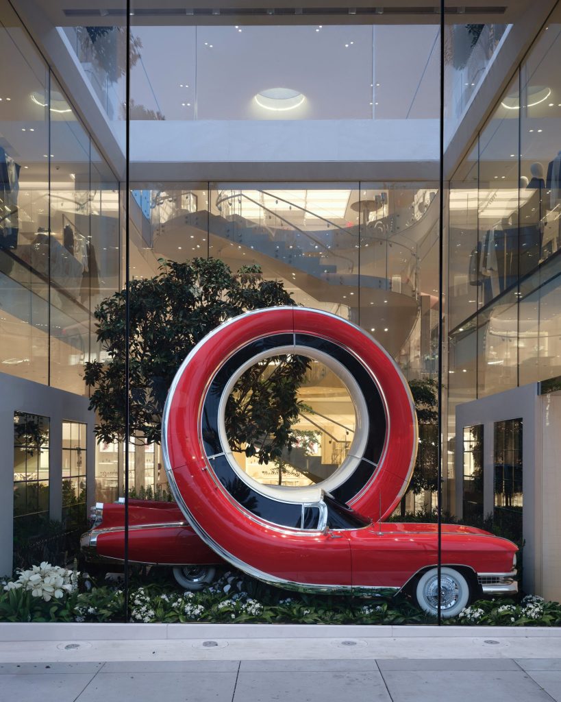 Red car sculpture forming a full vertical loop at House of Dior Beverly Hills
