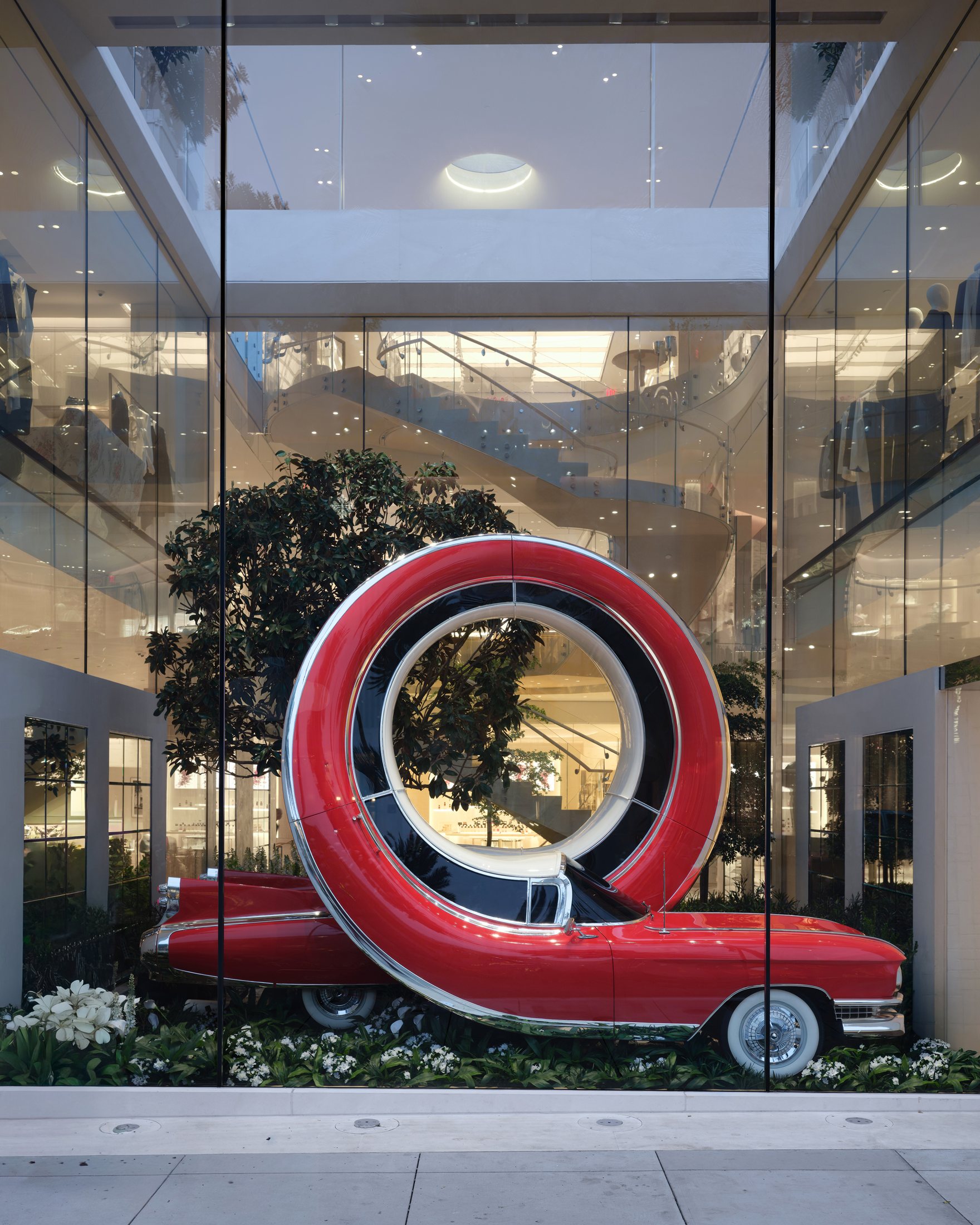 Red car sculpture forming a full vertical loop at House of Dior Beverly Hills
