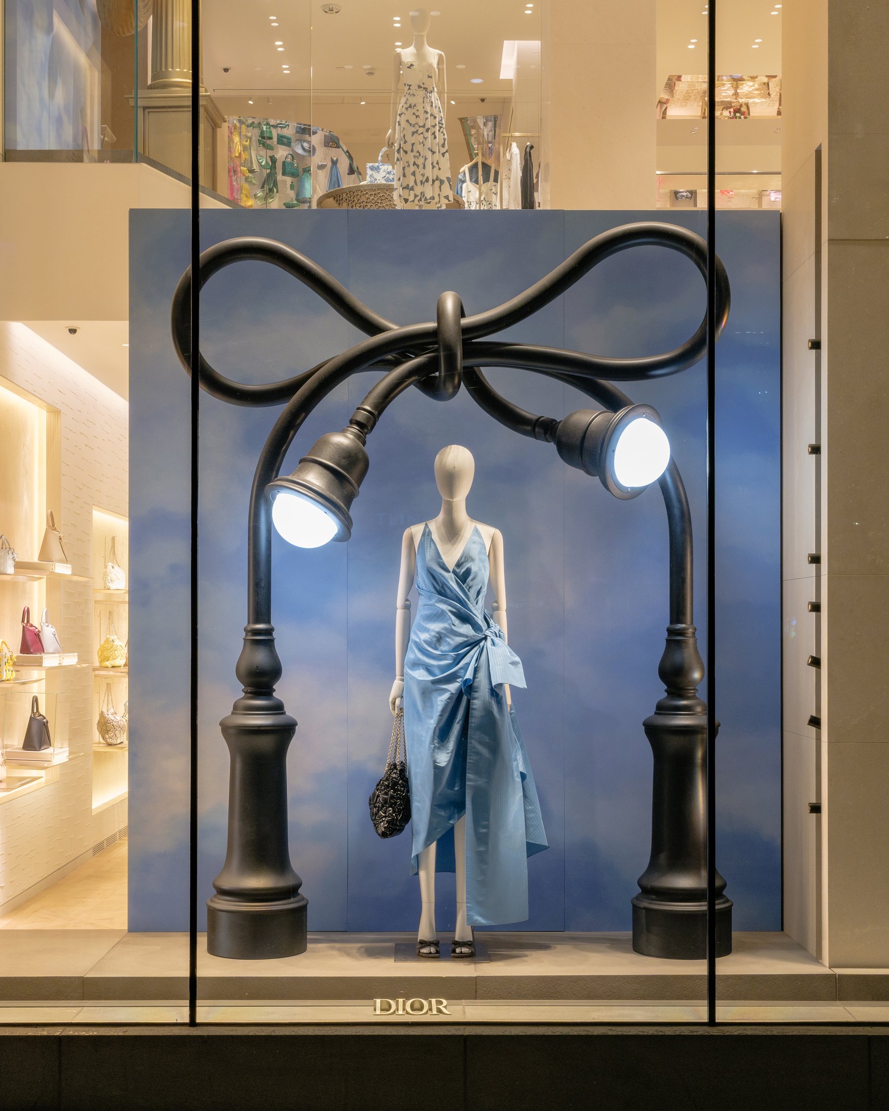 Street lamps tied into a bow over a dressed mannequin in New York