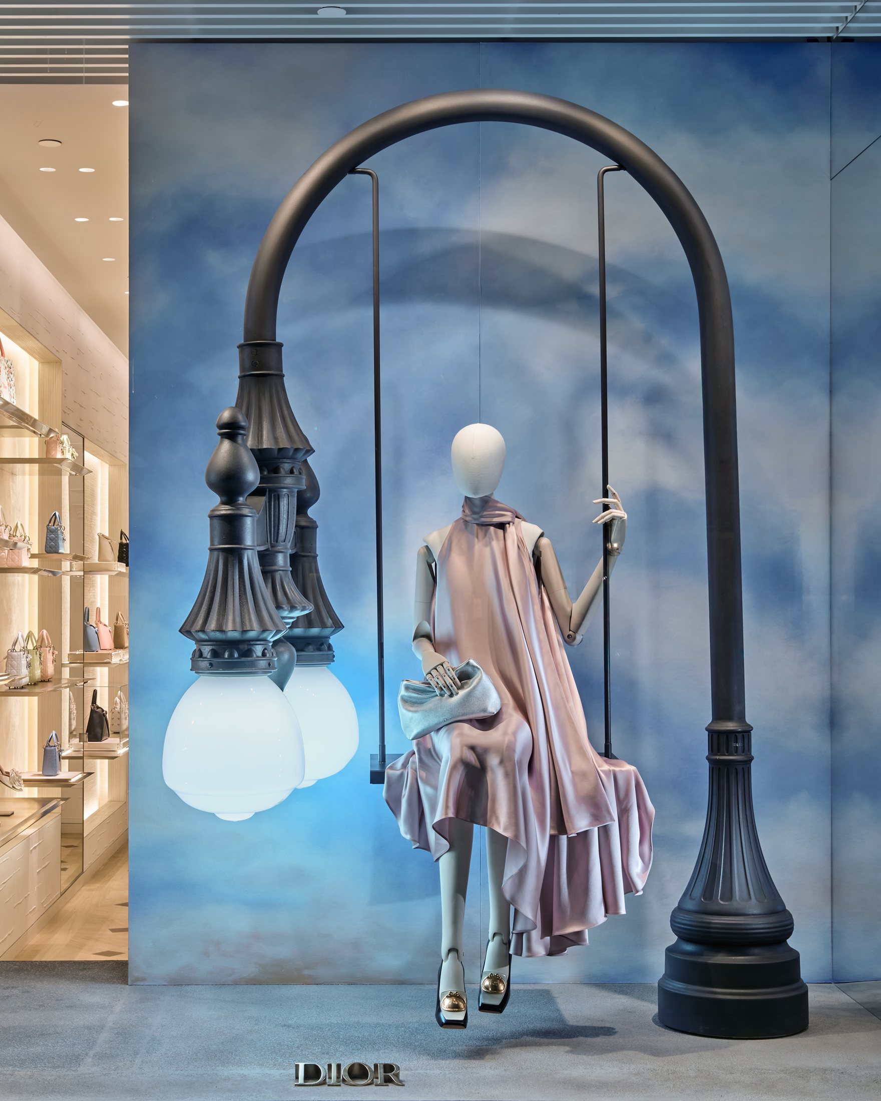 Arched street lamp supporting a swing with a dressed mannequin in Beverly Hills