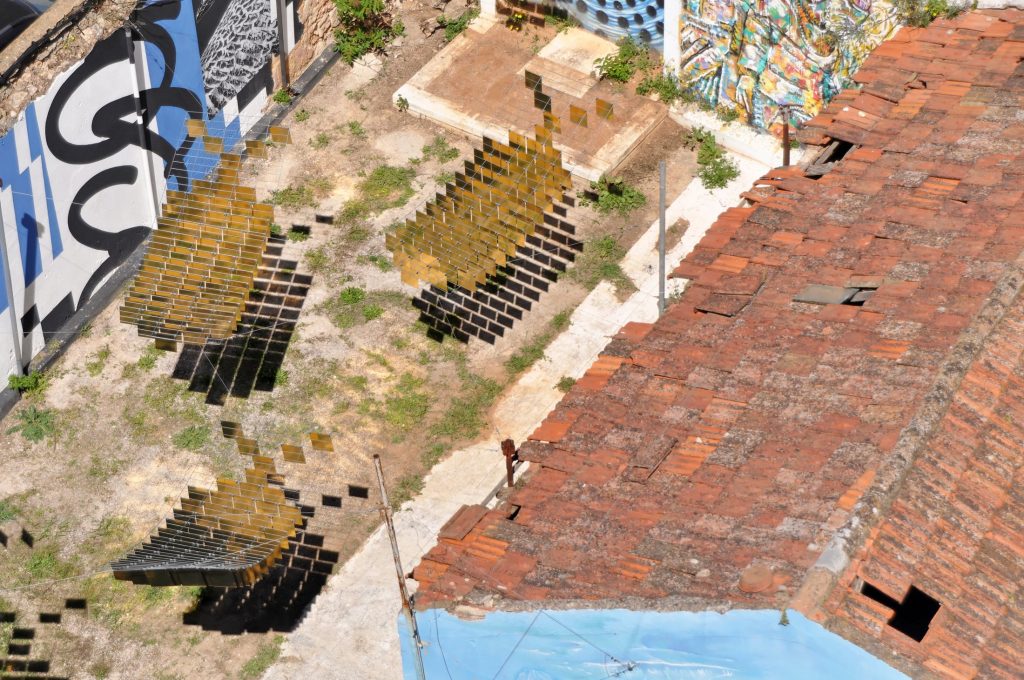 Aerial view of suspended golden fish and their shadows in the former brewery courtyard in Faro