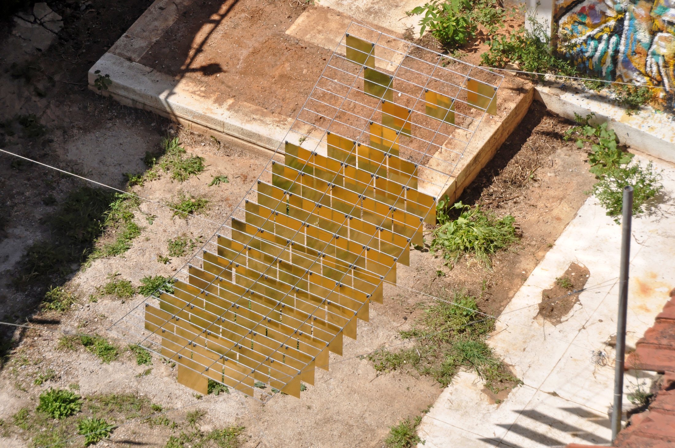 Overhead view of a fish silhouette assembled from rows of golden mirrored pieces