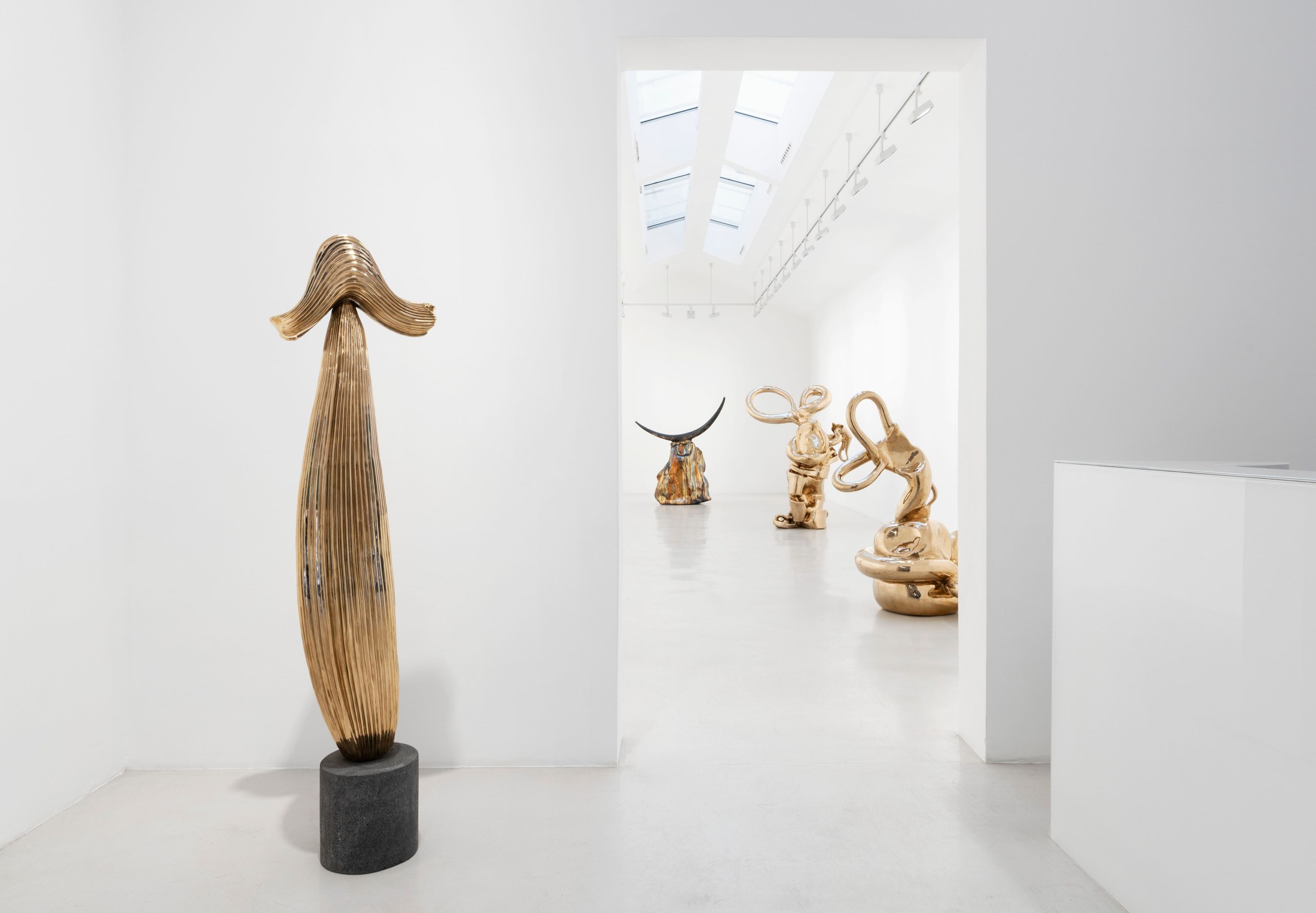 Upright bronze sculpture framing a view into Alma Allen’s exhibition at Perrotin Paris