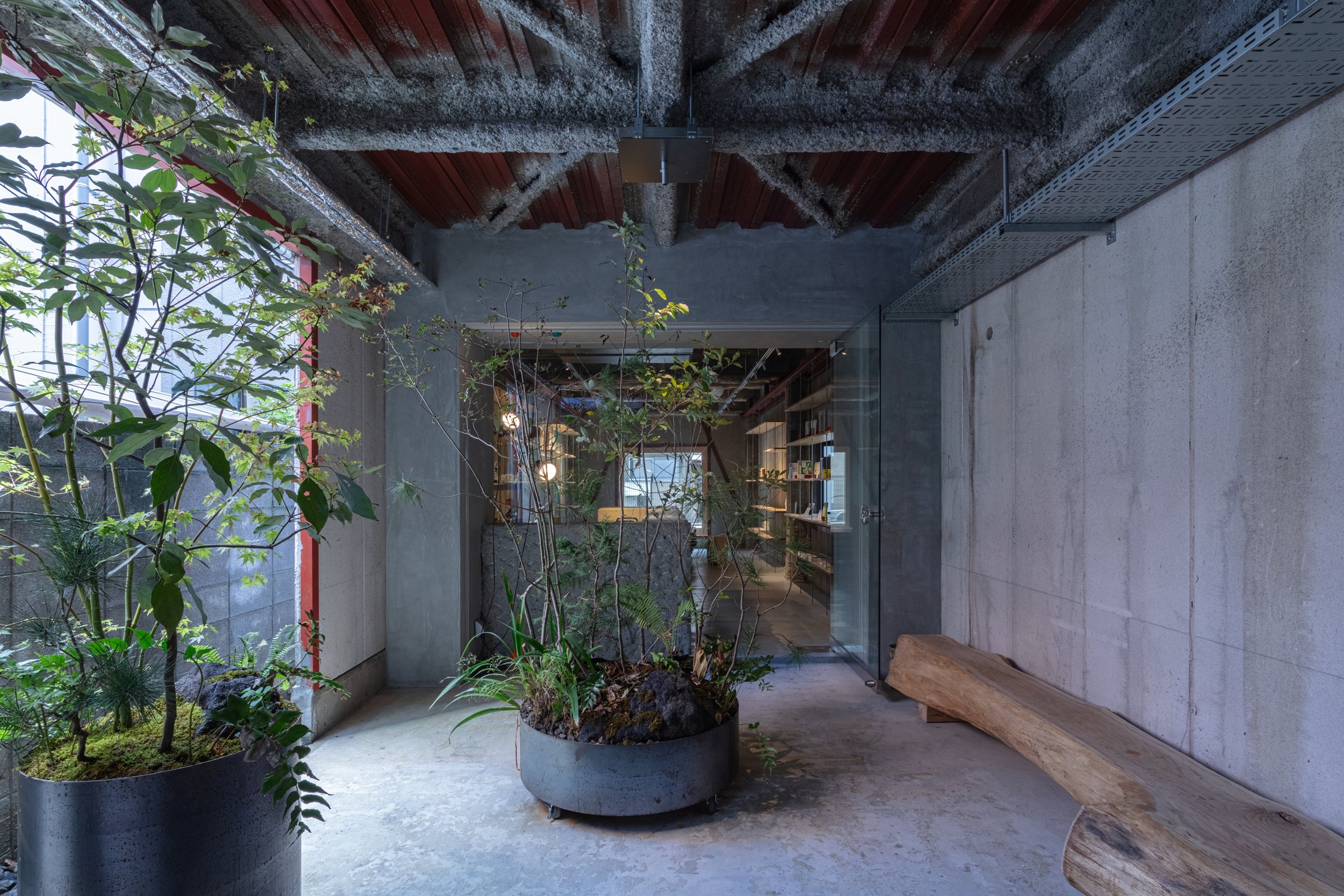 Maniwa entrance garden with circular steel planters and a timber bench