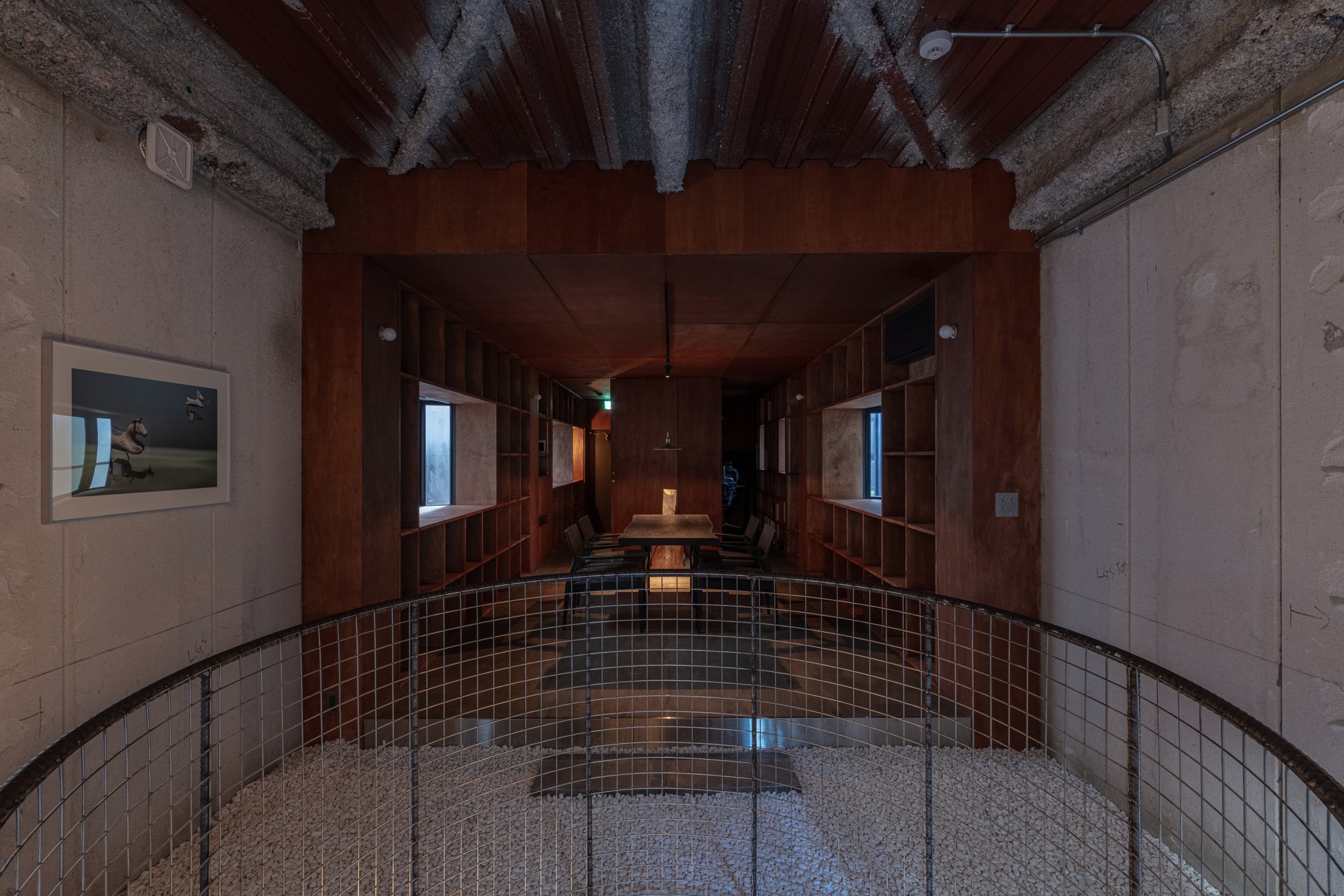 Upper-floor interior and circular mesh balustrade at Maniwa