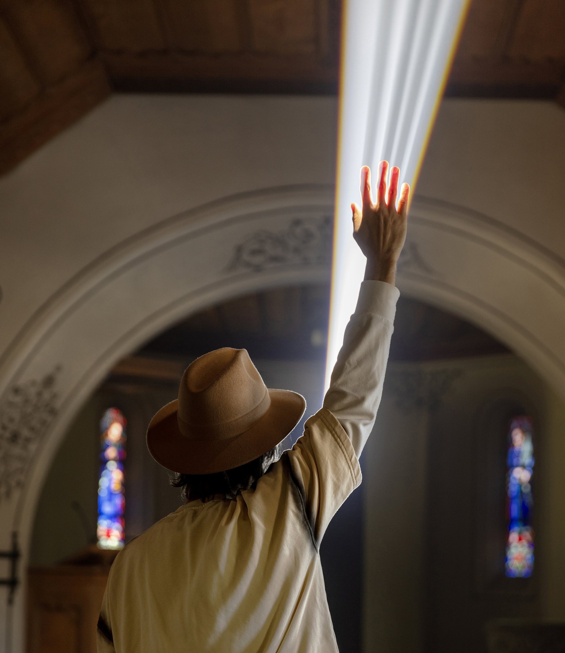 A visitor reaching towards the light in Liminal Journey