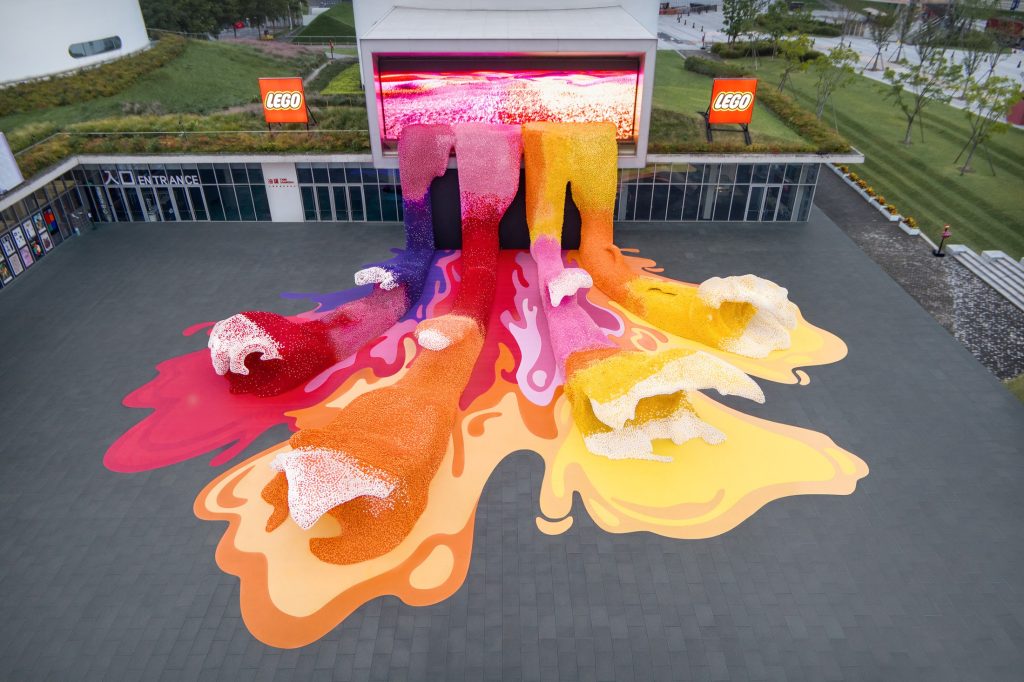 Pink orange and yellow LEGO Botanical Wave spreading across the museum forecourt