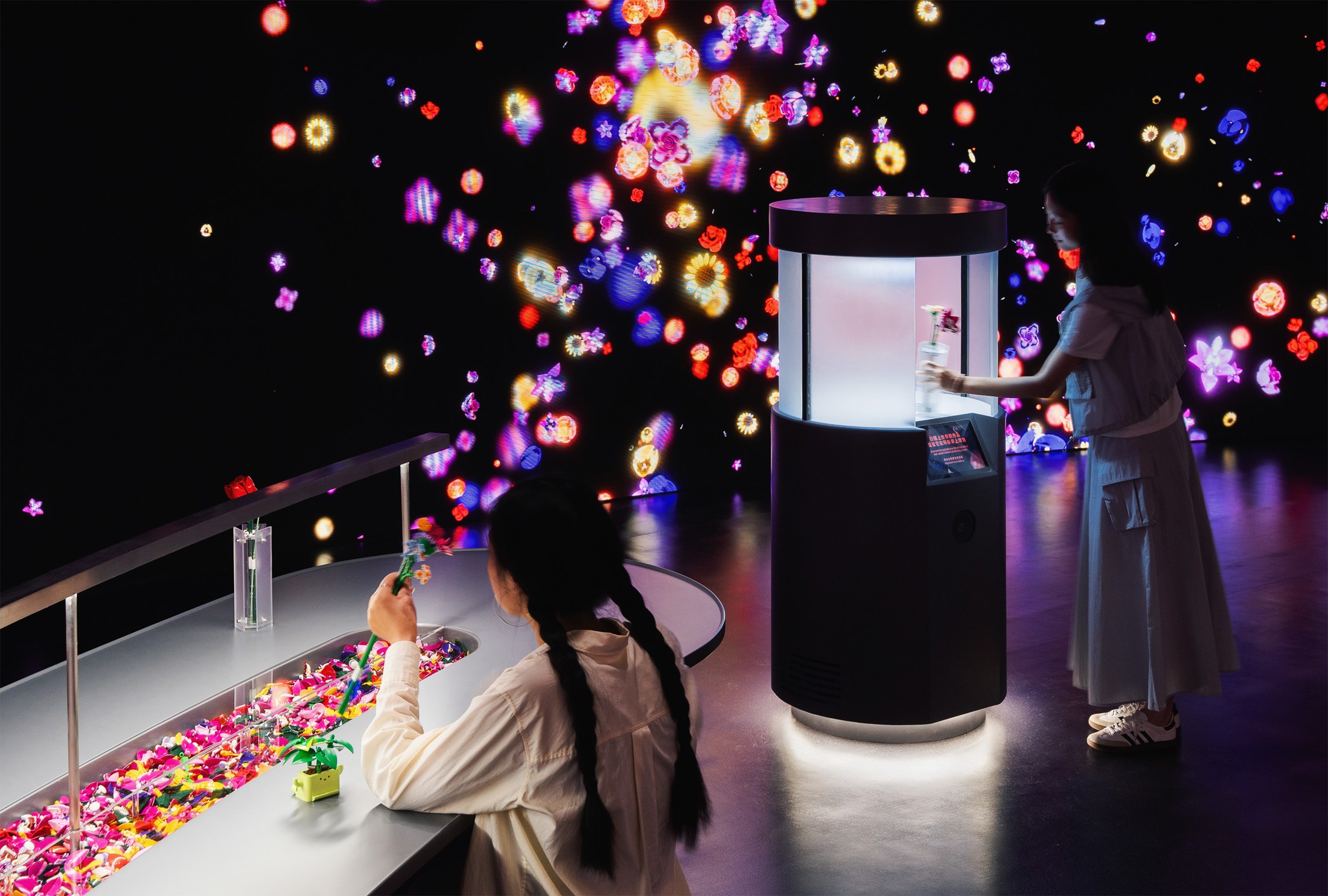 Visitor building a LEGO flower beside the digital display