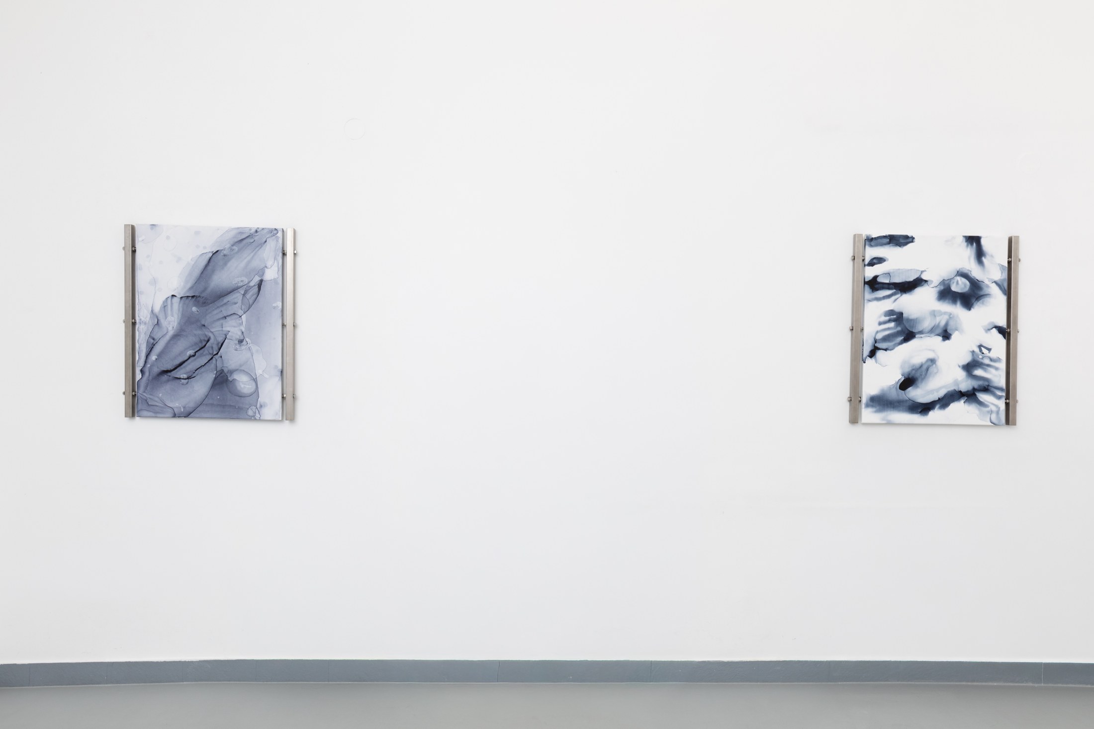 Two blue paintings on the gallery wall