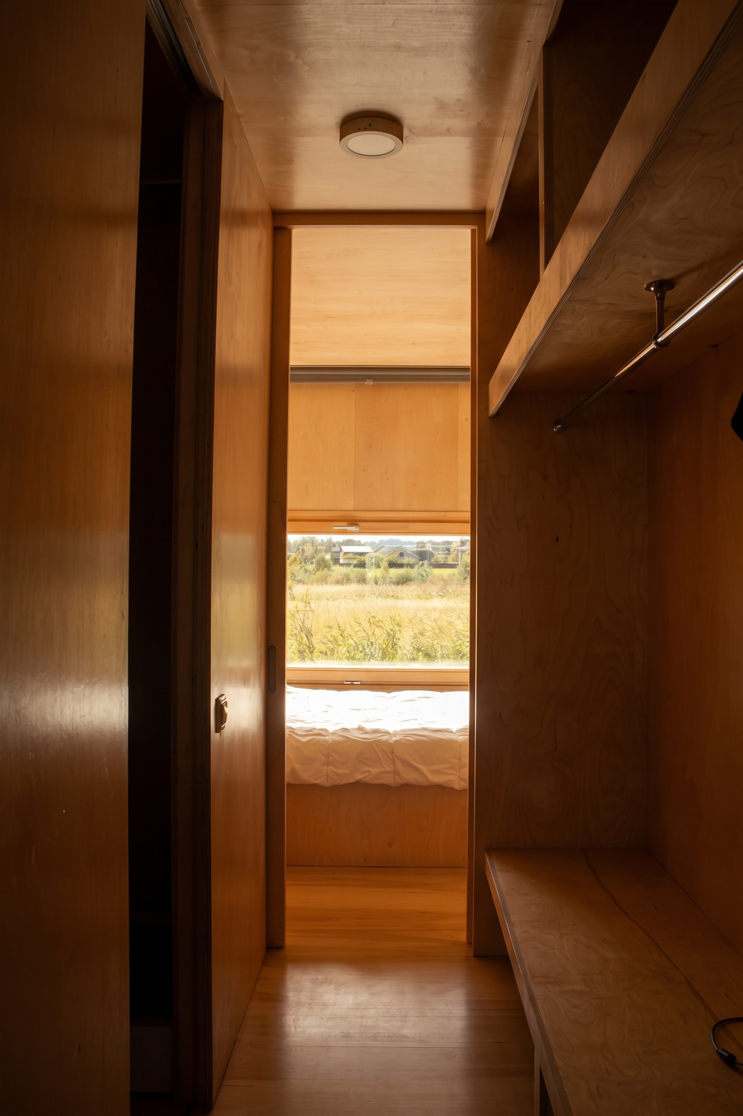 Narrow passage lined with integrated plywood storage