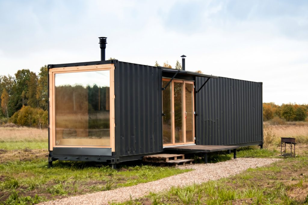 Dark shipping container house with large glazed openings
