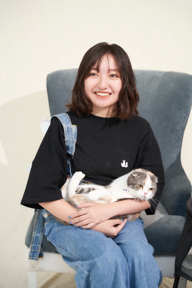 ソファーに座っている女性と猫 自動的に生成された説明