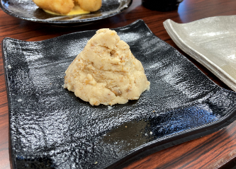 木製テーブルの上に置かれた肉料理 低い精度で自動的に生成された説明