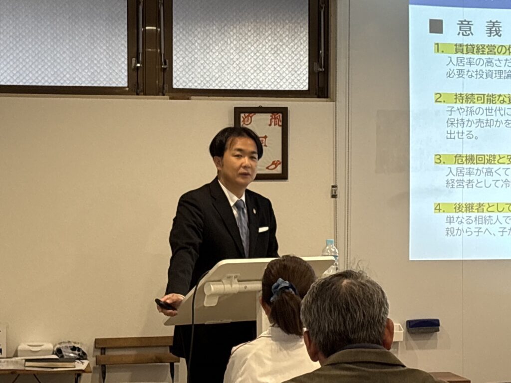 後継者育成塾（金沢市）の講義で、講師が賃貸経営における資産継承の意義を専門スライドとともに説明している様子