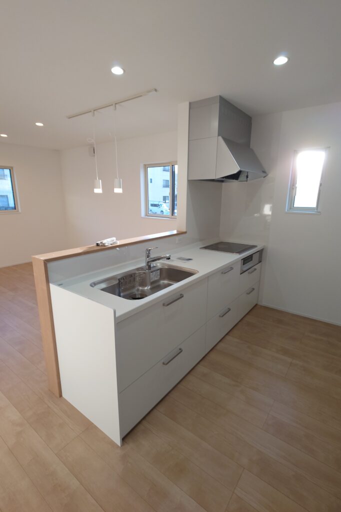 金沢市涌波の戸建賃貸住宅のキッチンとLDK。対面キッチンを採用し、明るく開放感のある室内空間が特徴。